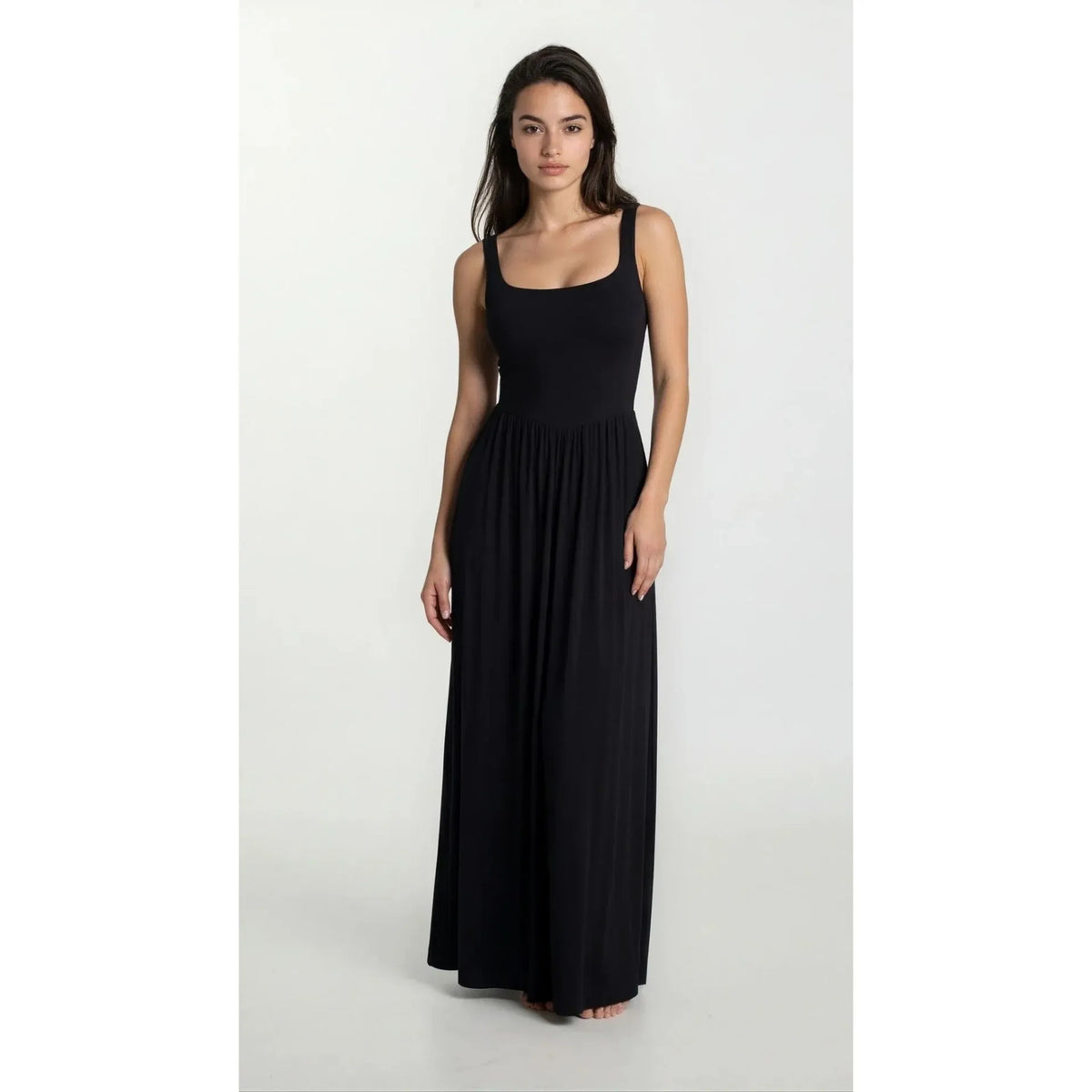 Model wearing Priv Dawn Maxi Dress in silky-jersey black, a full-length gown with a fitted bodice and flowing skirt.
