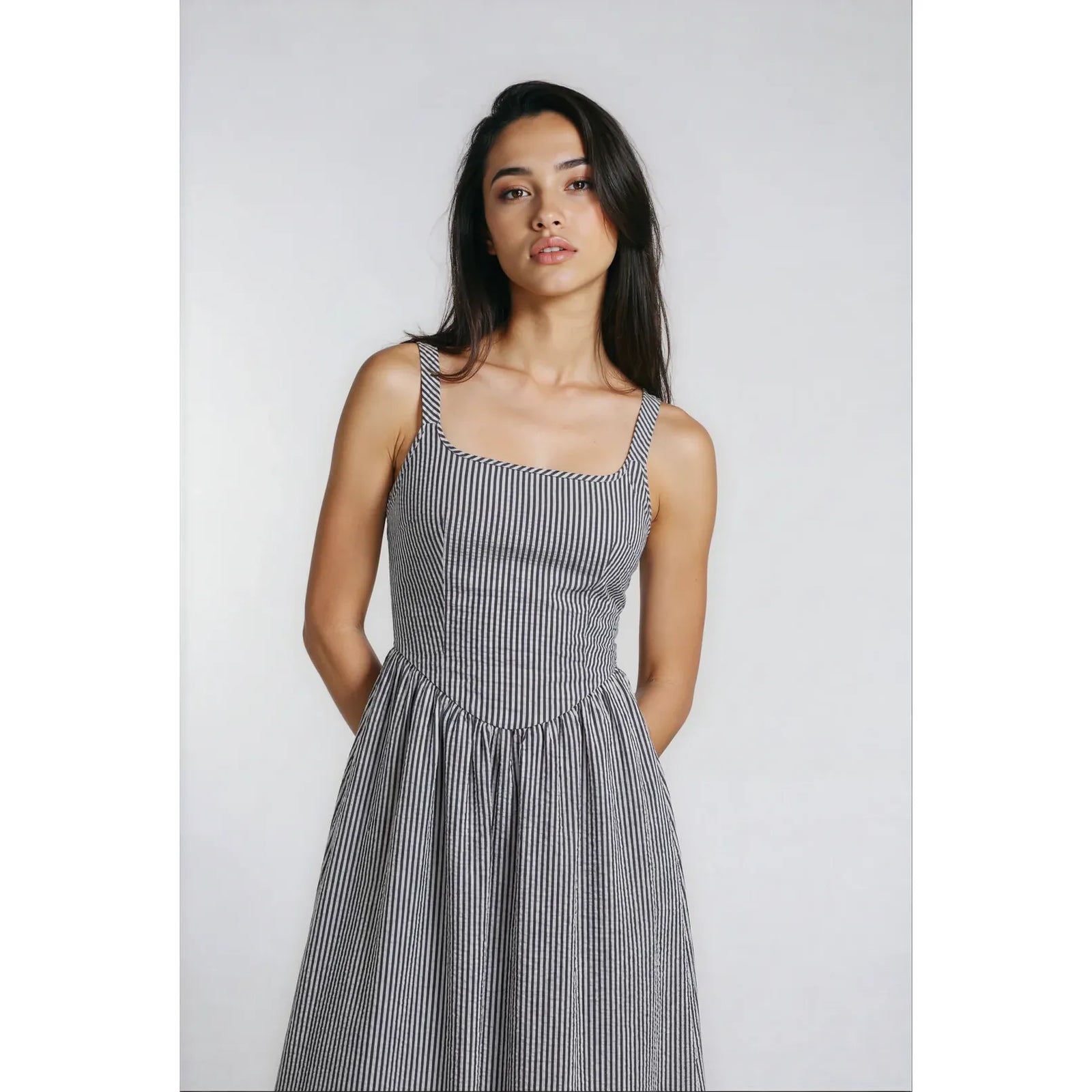 Model wearing Priv Jules Tie Back Dress in black and white striped crepe Bengal with a tie-back.