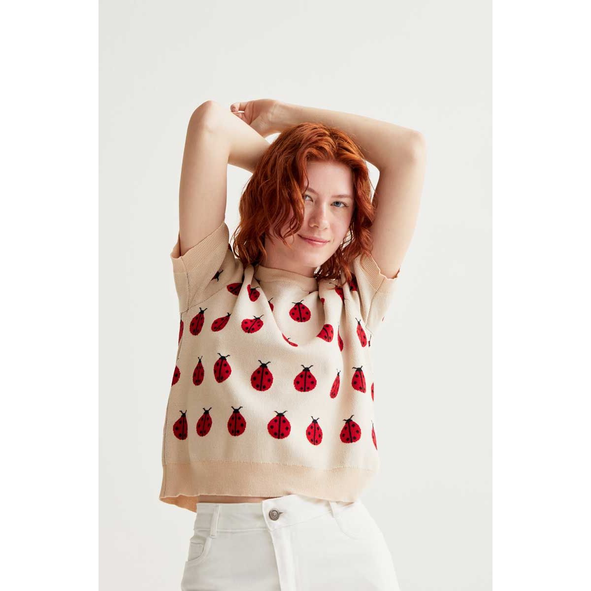 Red Coccinelle Print Tee on beige knit with red ladybug pattern, puff sleeves, and round neckline.