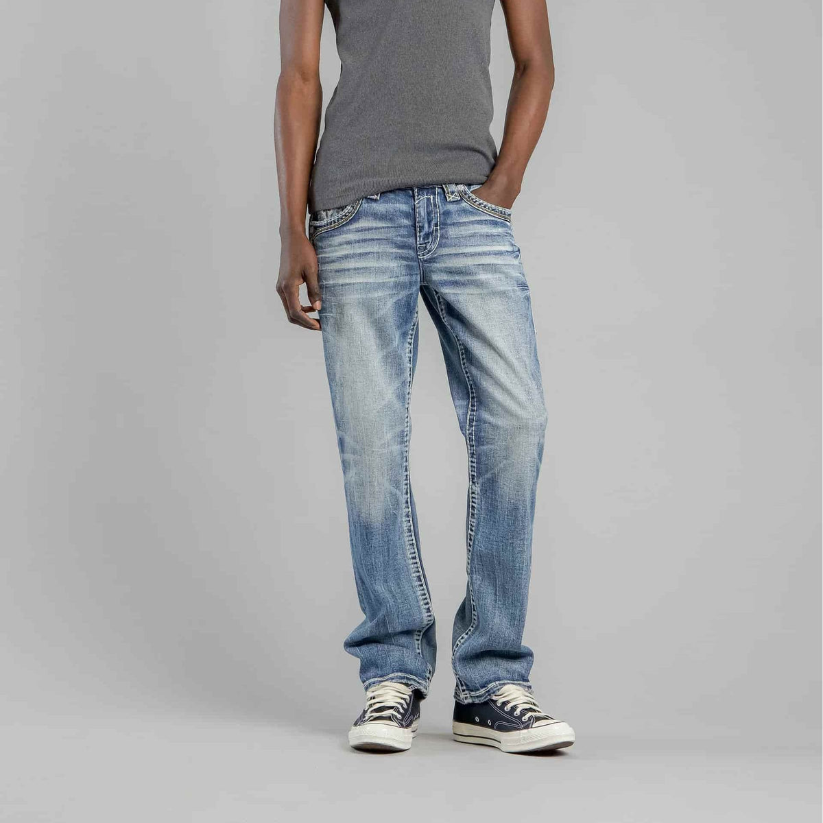 Rock Revival Andrew B200 Bootcut jeans in a medium blue wash with stretch denim on a model wearing a gray top.