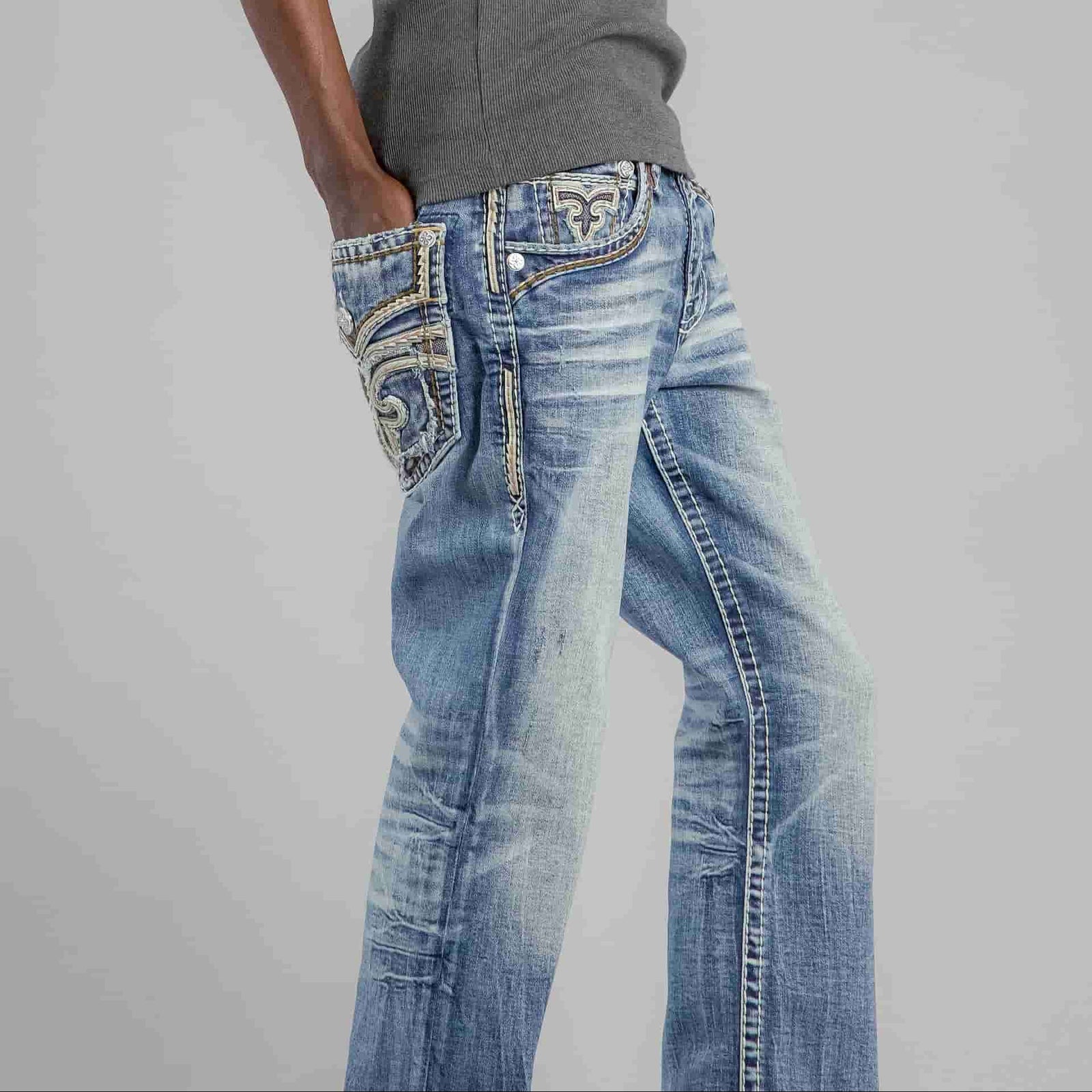 Rock Revival Andrew B200 Bootcut jeans in a medium blue wash with stretch denim on a model wearing a gray top.