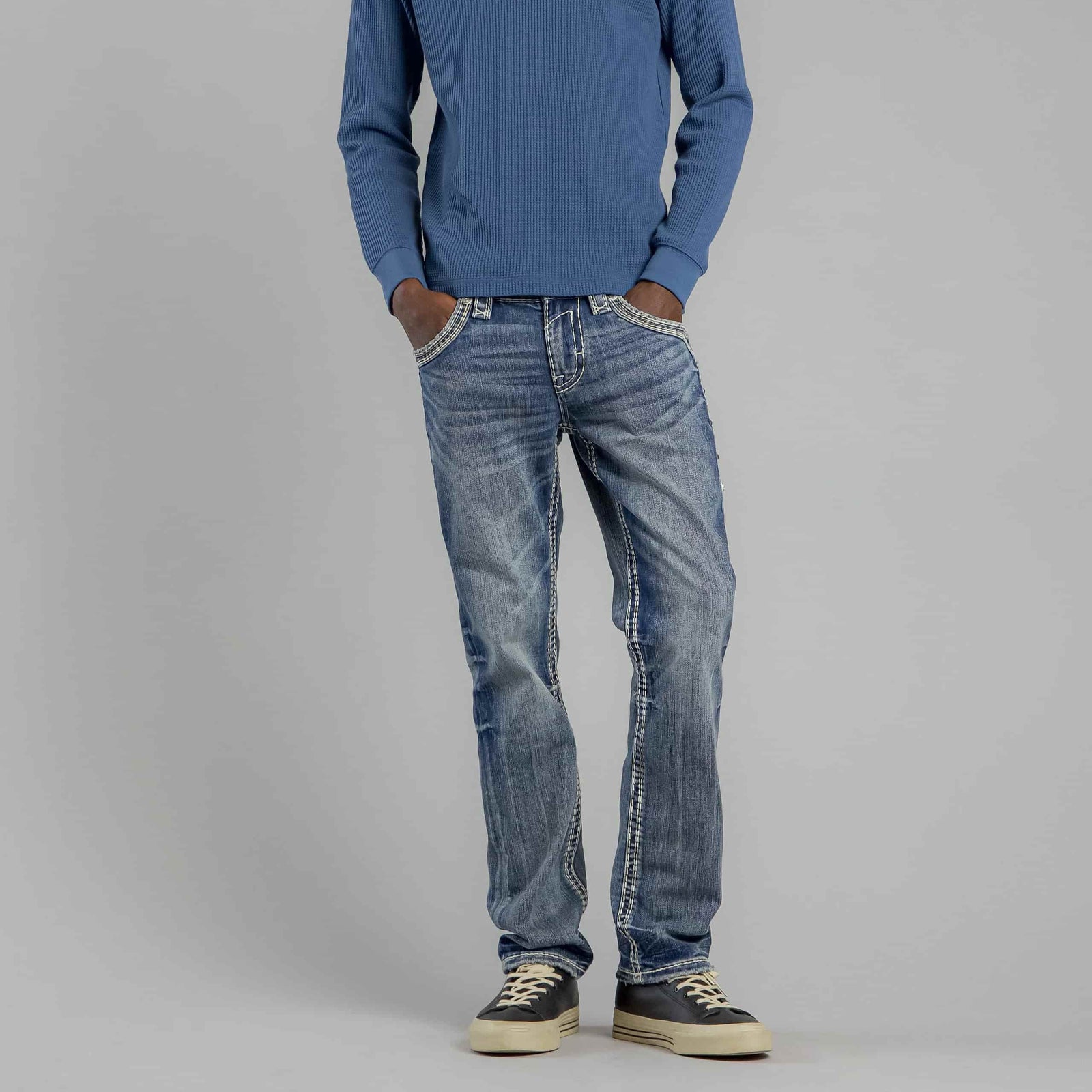 Rock Revival Brayen J246 Straight jeans on a model wearing a blue knit sweater and sneakers