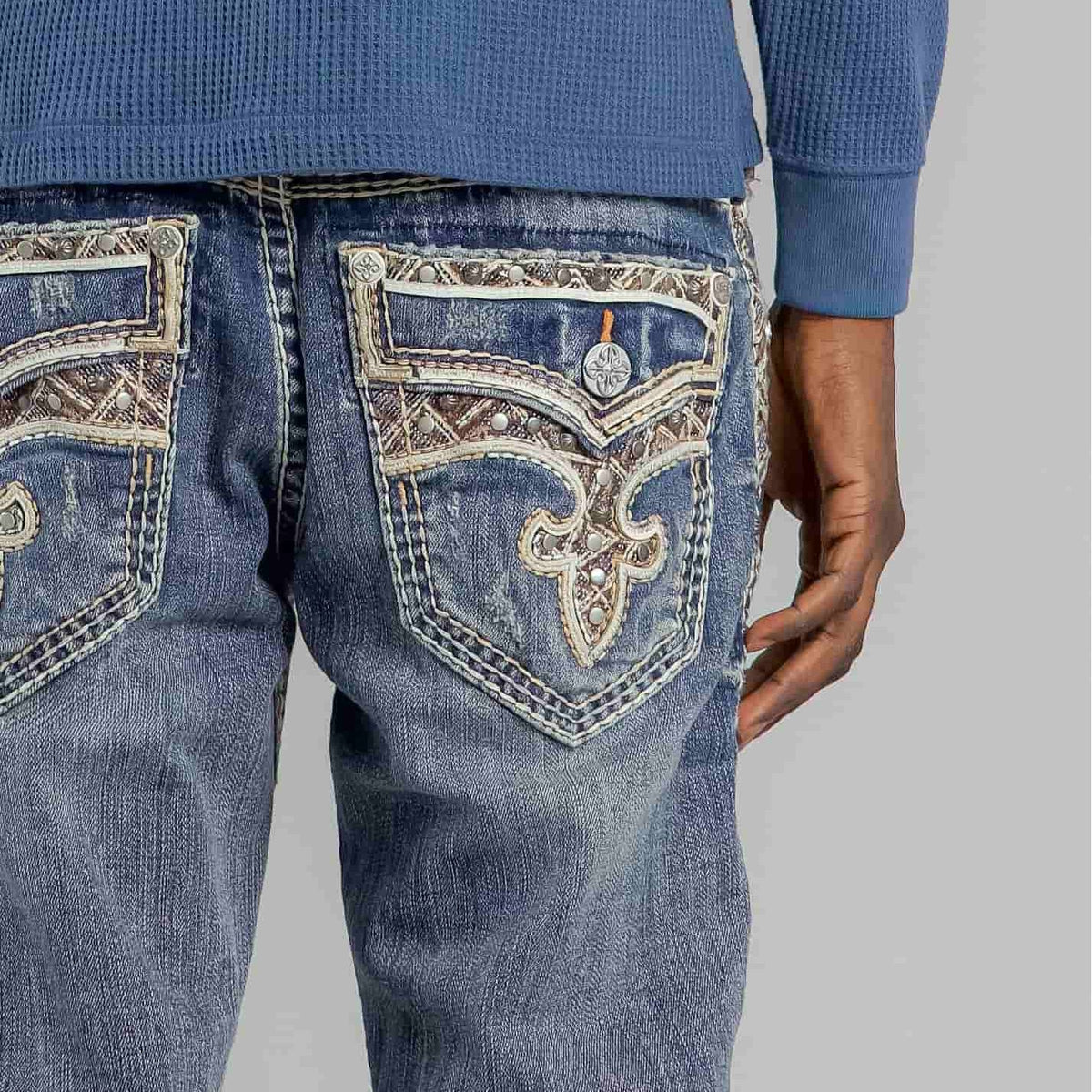 Rock Revival Brayen J246 Straight jeans with ornate back pockets, fleur-de-lis embroidery, and metal studs.
