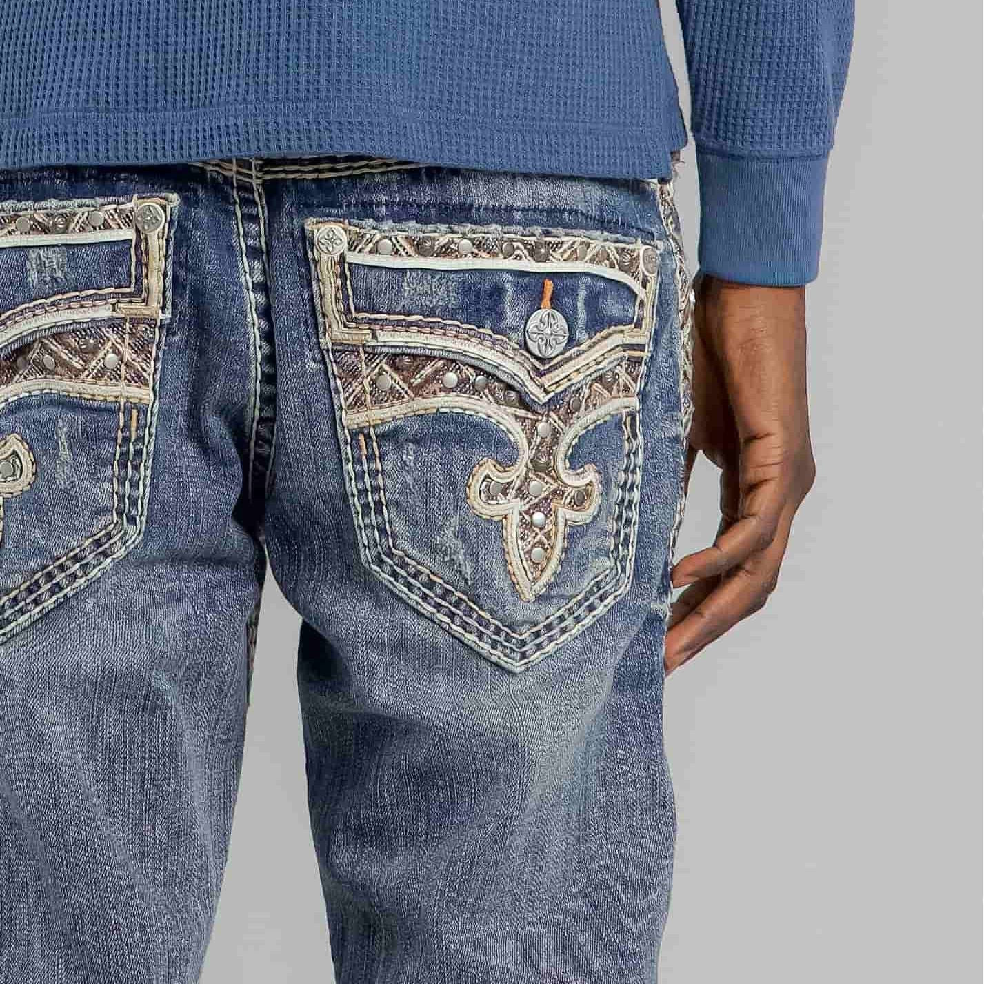 Rock Revival Brayen J246 Straight jeans with ornate back pockets, fleur-de-lis embroidery, and metal studs.