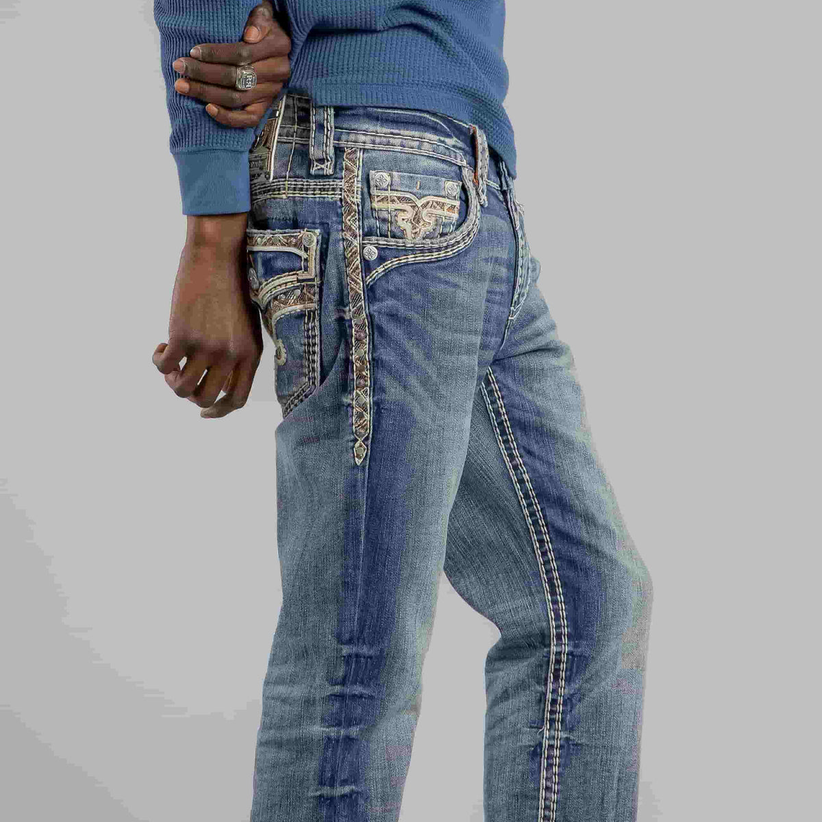 Rock Revival Brayen J246 Straight jeans with decorative stitching and cargo pockets on a man wearing a blue knit top.