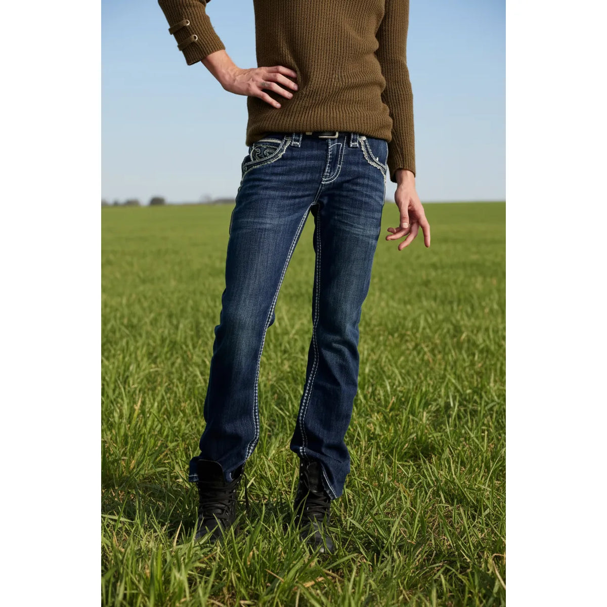 Rock Revival Braylon B202 Bootcut jeans in medium indigo wash on a model wearing a brown sweater outdoors.