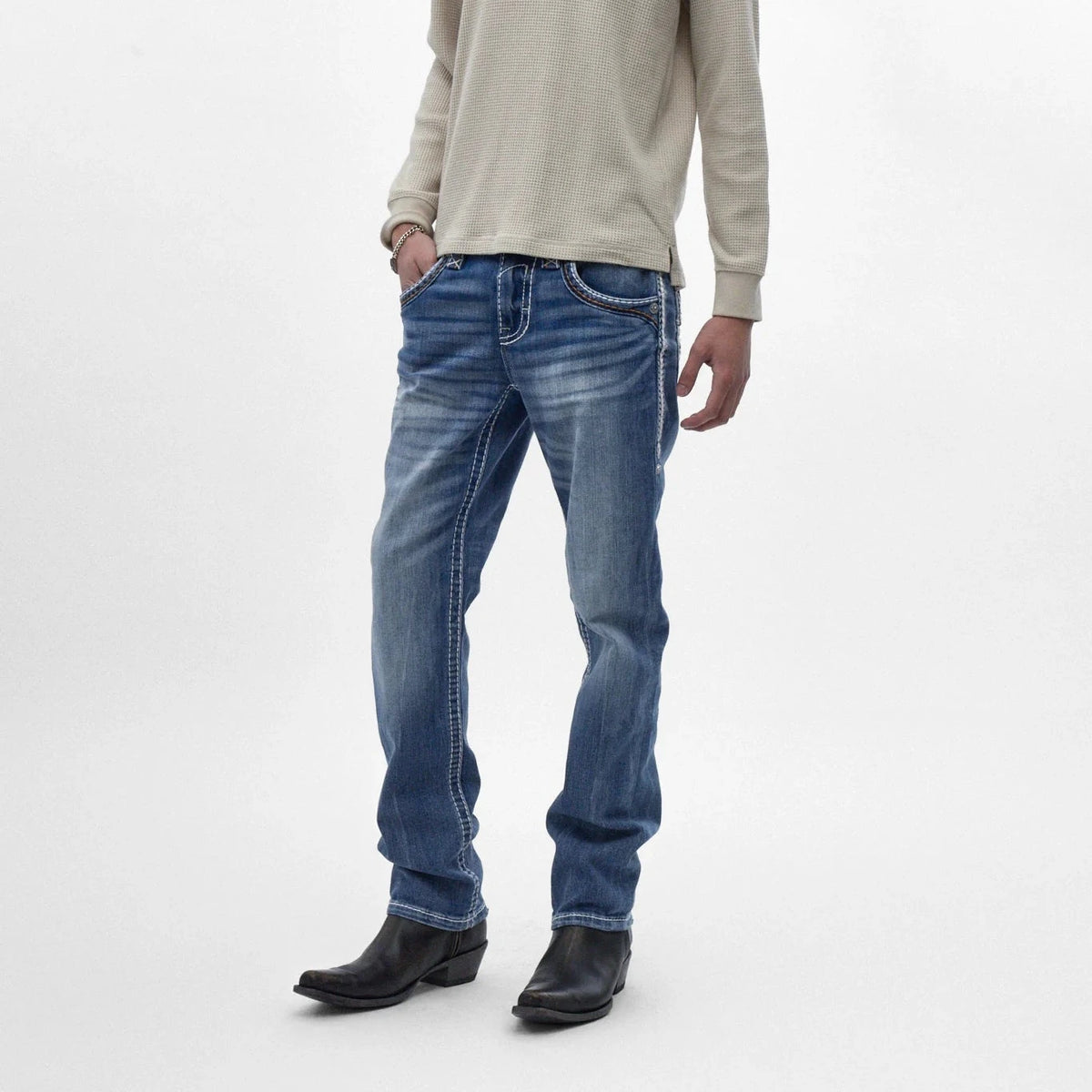 Rock Revival Caleb J200 straight-leg jeans in indigo with fading and contrasting stitching, styled with black cowboy boots.