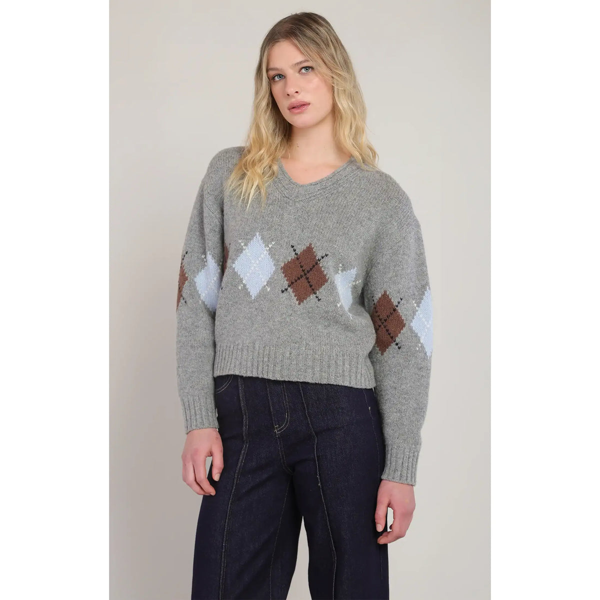 Gray V-neck argyle sweater featuring brown and light blue diamond patterns on a heathered knit sweater with ribbed trim.