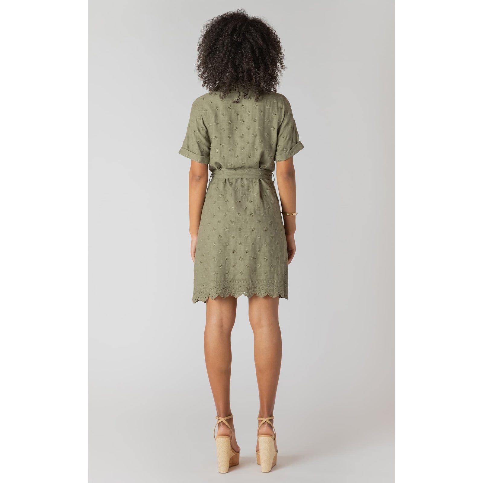 Sage linen belted mini shirt dress with eyelet embroidery and scalloped hem, model wearing it.