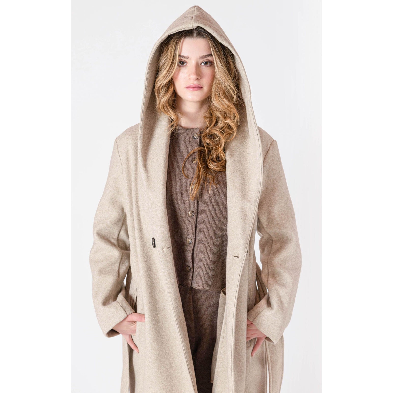 Room 34 Belted Hooded Coat in beige, long belted coat with hood and front buttons worn by a model.