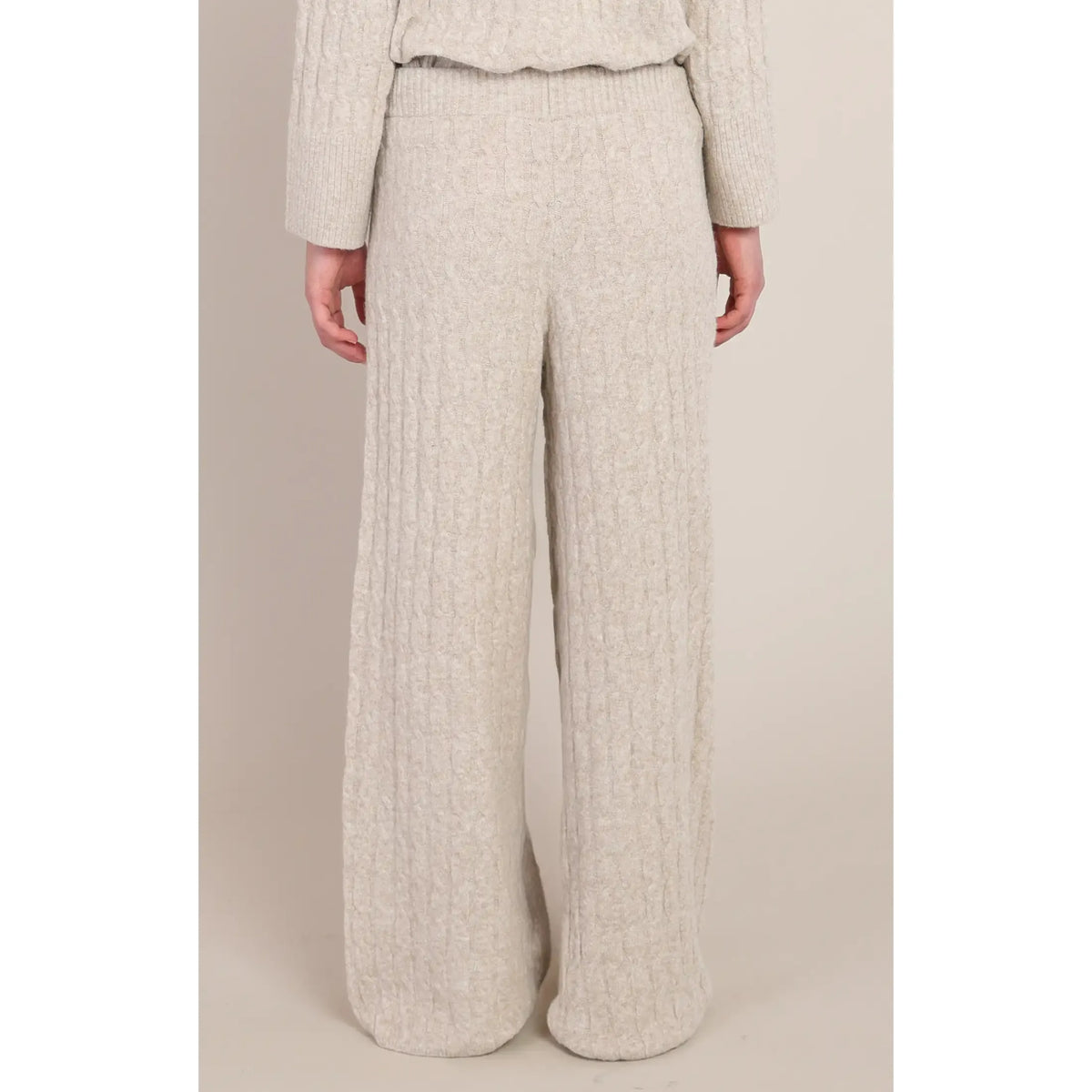 Beige cable knit pants featuring a cozy wool-infused knit, relaxed wide-leg fit, and easy-pull-on elastic waist for luxurious lounging.