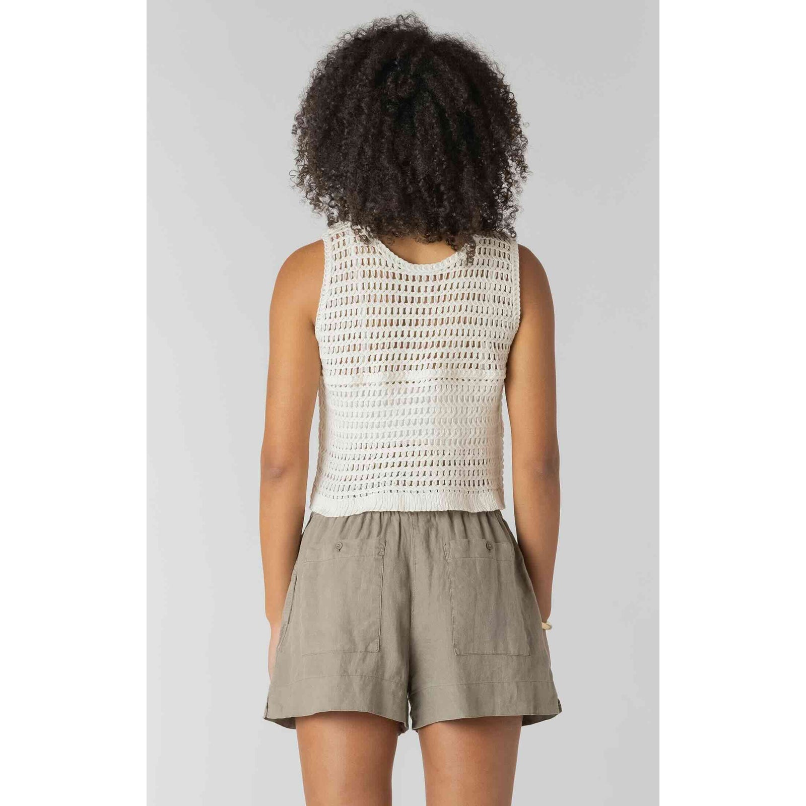 Room 34 Crochet Buttoned Vest on model, cream sleeveless open-knit top paired with khaki shorts.
