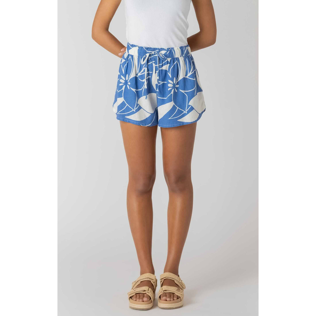 Room 34 Elastic Waist Shorts in Azure Floral with a drawstring waist, paired with a white top and beige sandals.