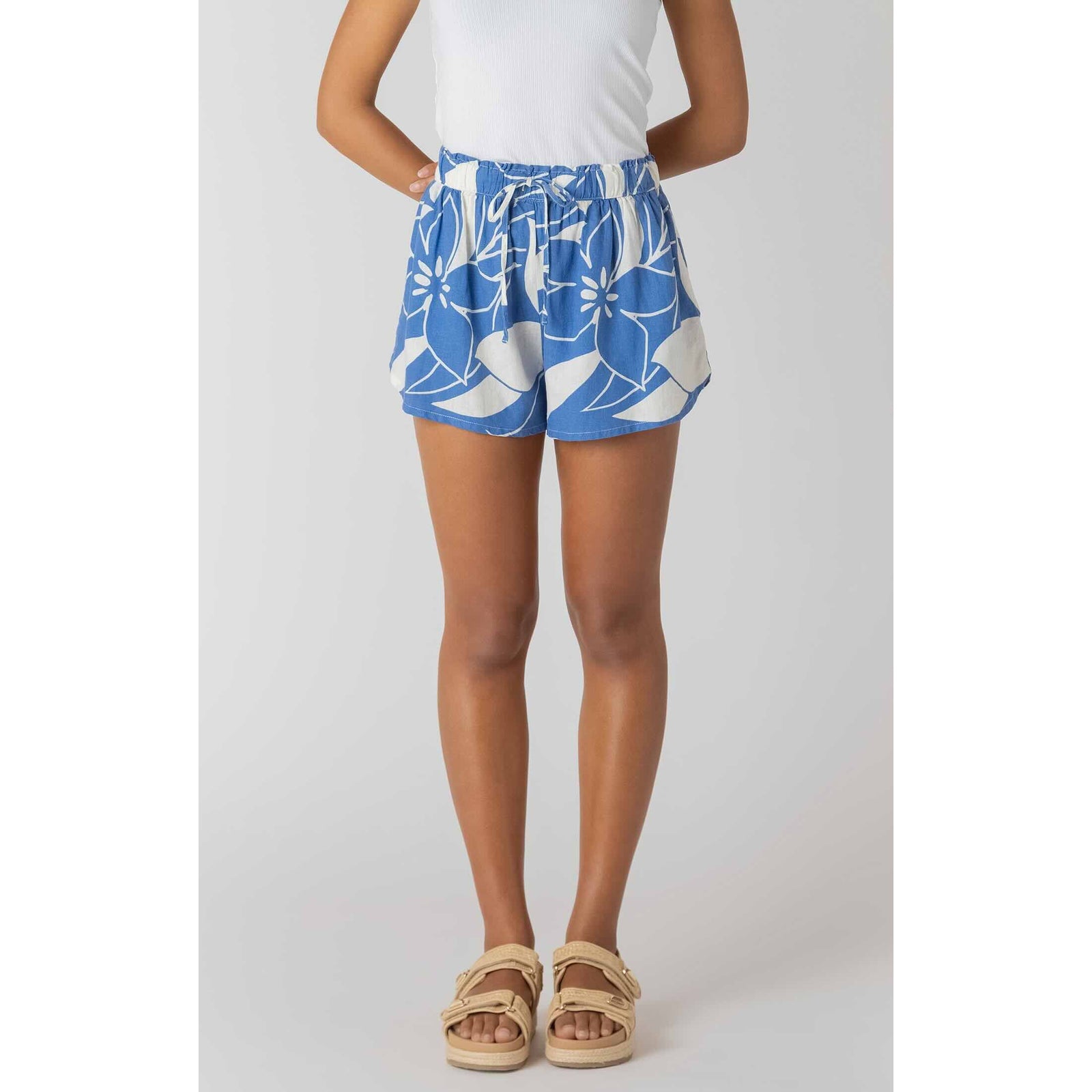 Room 34 Elastic Waist Shorts in Azure Floral with a drawstring waist, paired with a white top and beige sandals.