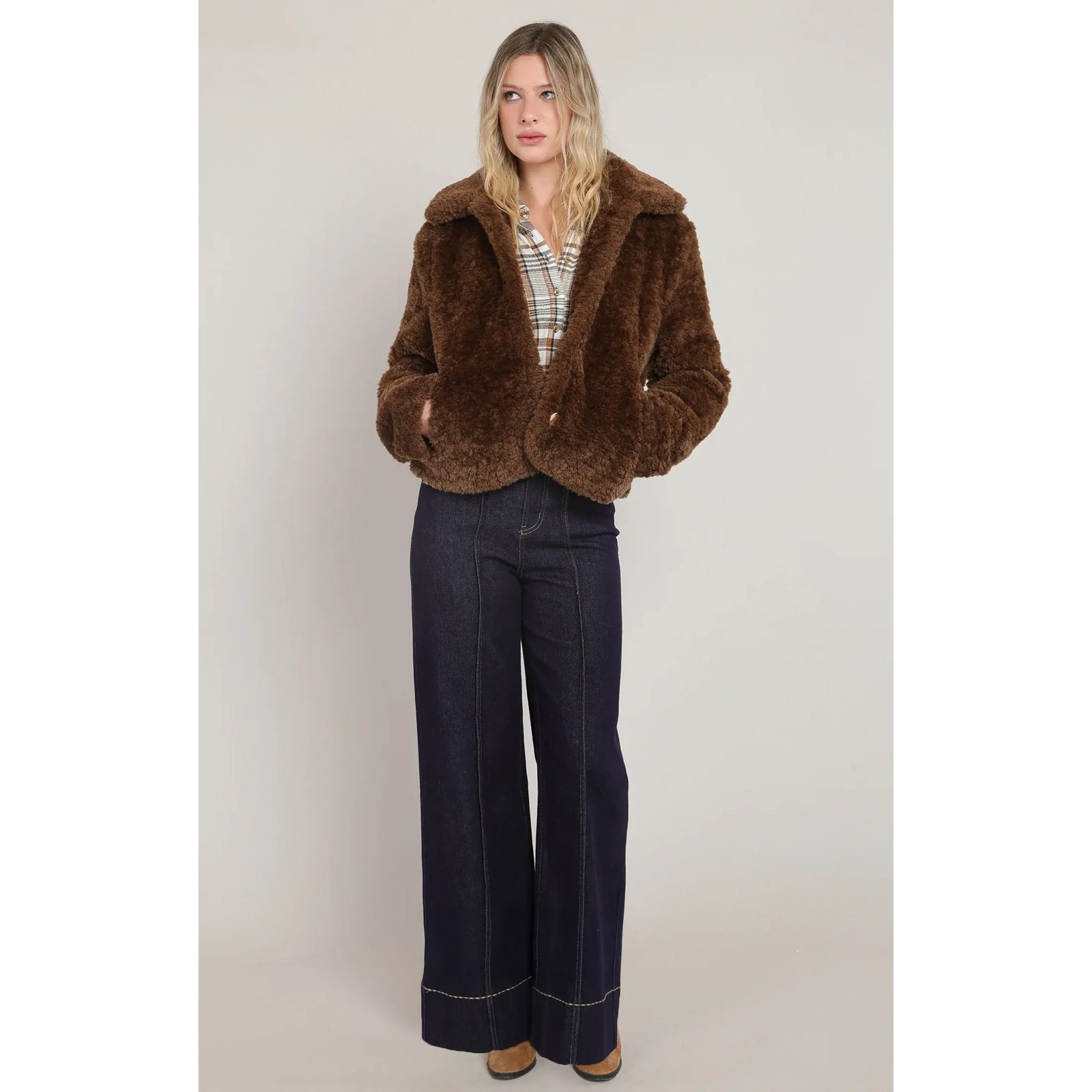 Brown faux fur coat featuring a plush texture, wide collar, gold buttons, and side pockets for cool-weather warmth.