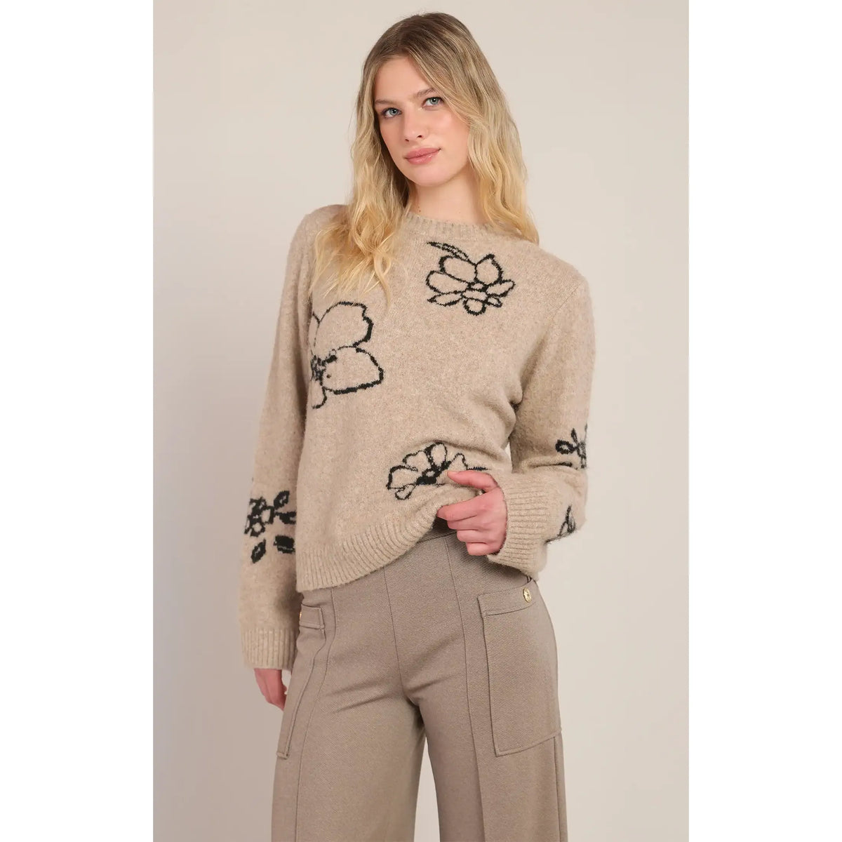 Taupe crewneck sweater featuring soft knit texture and unique black contrast floral accents on the chest and sleeves.