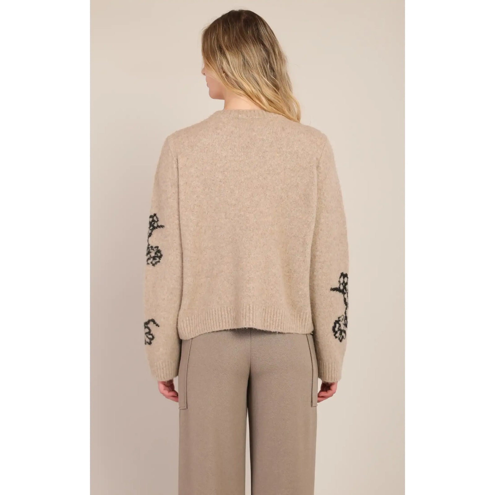 Back view of a taupe room 34 flower crewneck sweater featuring contrast black floral accents on the sleeves.