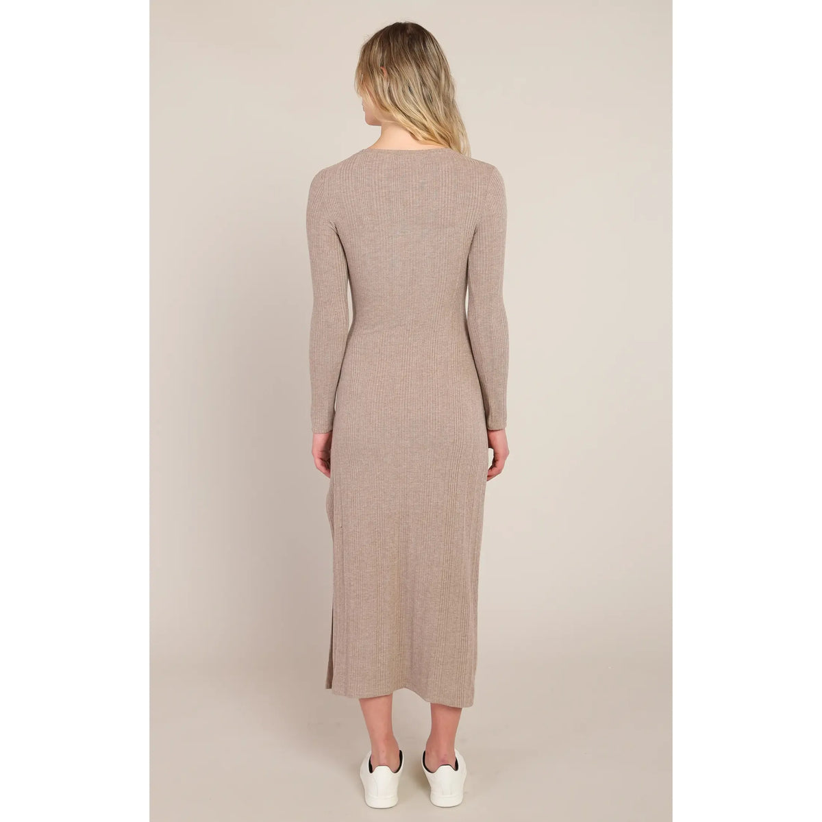Back view of beige ribbed long dress with long sleeves and side slit. Knot waist detail defines the silhouette for elegant fall styling.