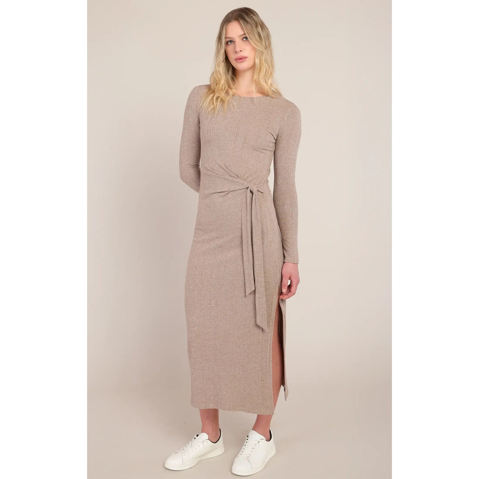 Beige ribbed long dress featuring a signature knotted waist detail and side slit, styled with white sneakers for versatile fall elegance.