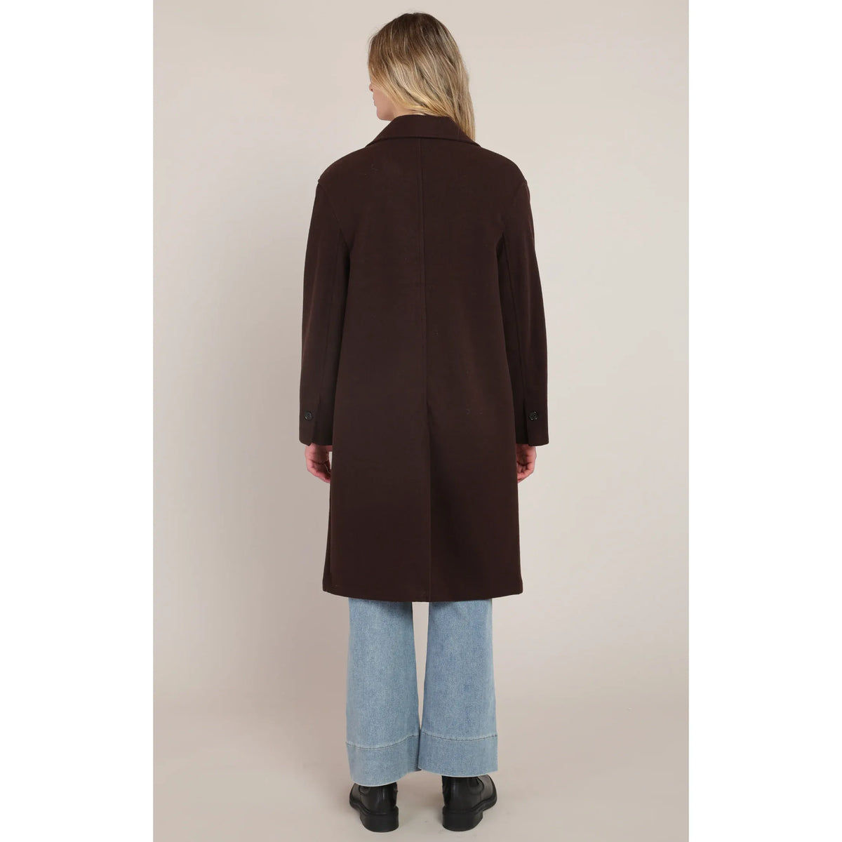 Back view of a dark brown long soft coat with a central seam. Pair with wide-leg jeans for lightweight sophistication.