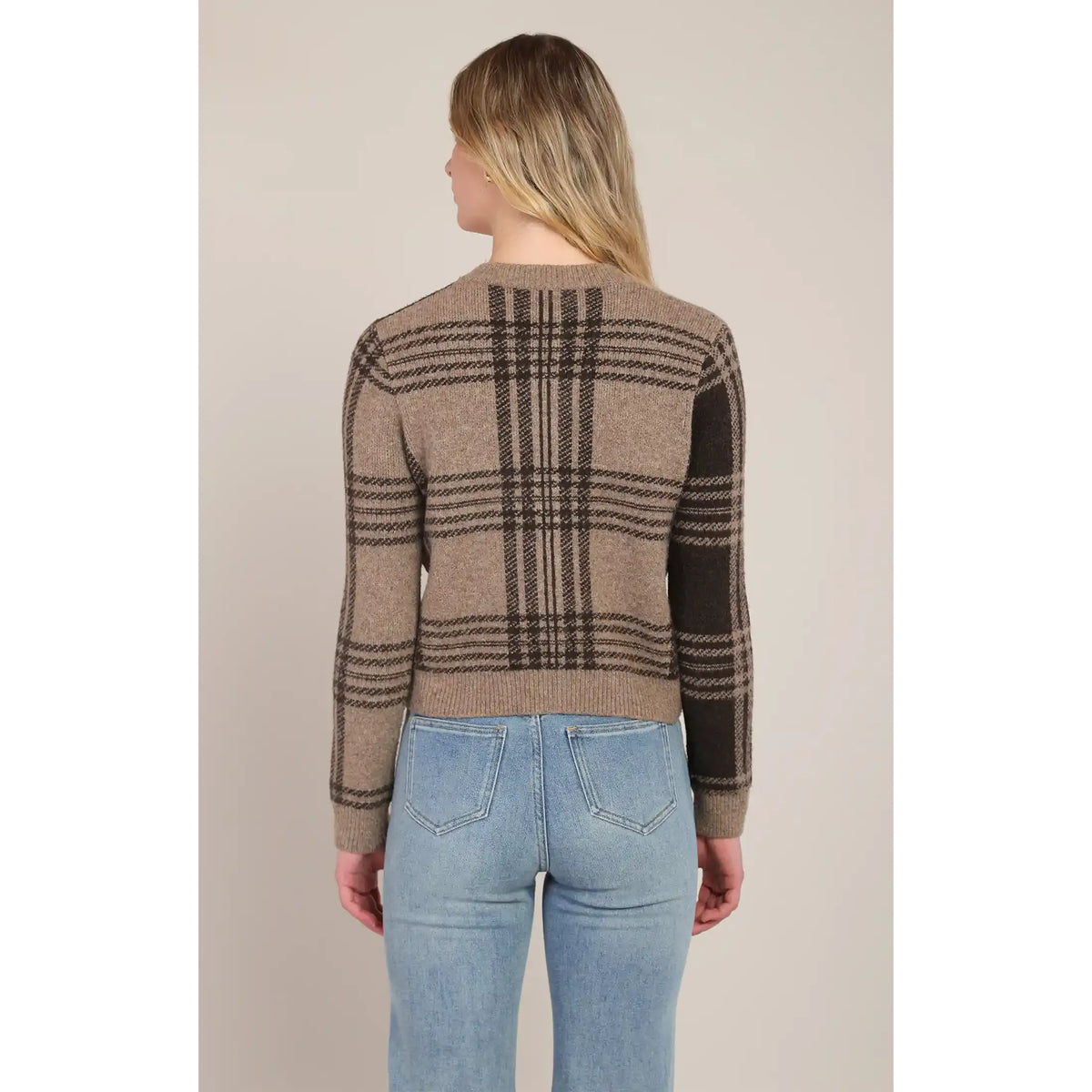 Back view of a taupe-brown plaid cardigan featuring a stretch knit pattern and medium-length fit paired with blue jeans.