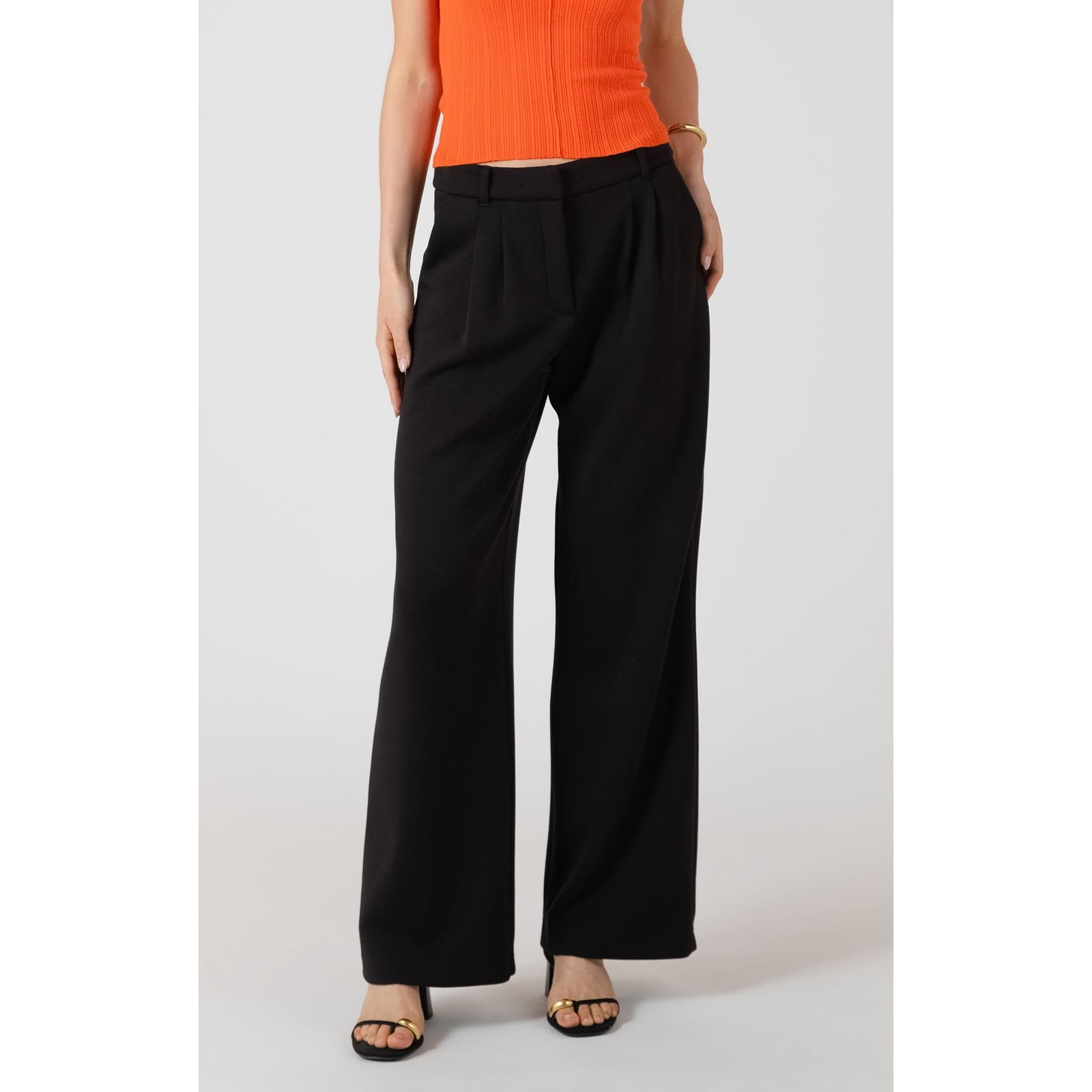 Room 34 Scuba Knit Trouser, black wide-leg pants worn with an orange top.