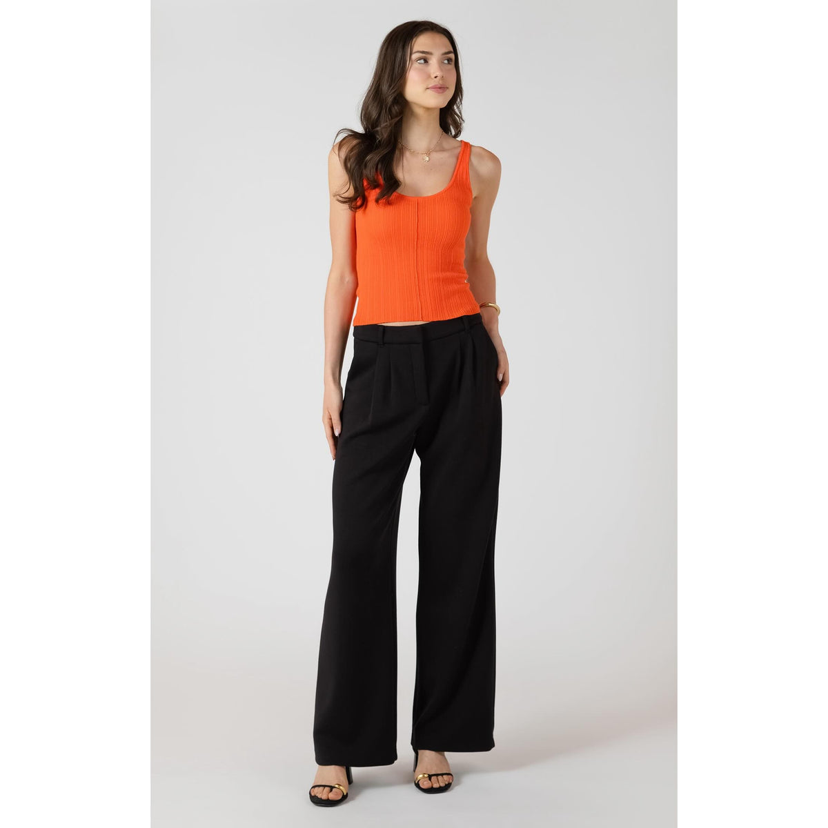 Room 34 Scuba Knit Trouser worn as black wide-leg pants on a model with an orange rib-knit top.