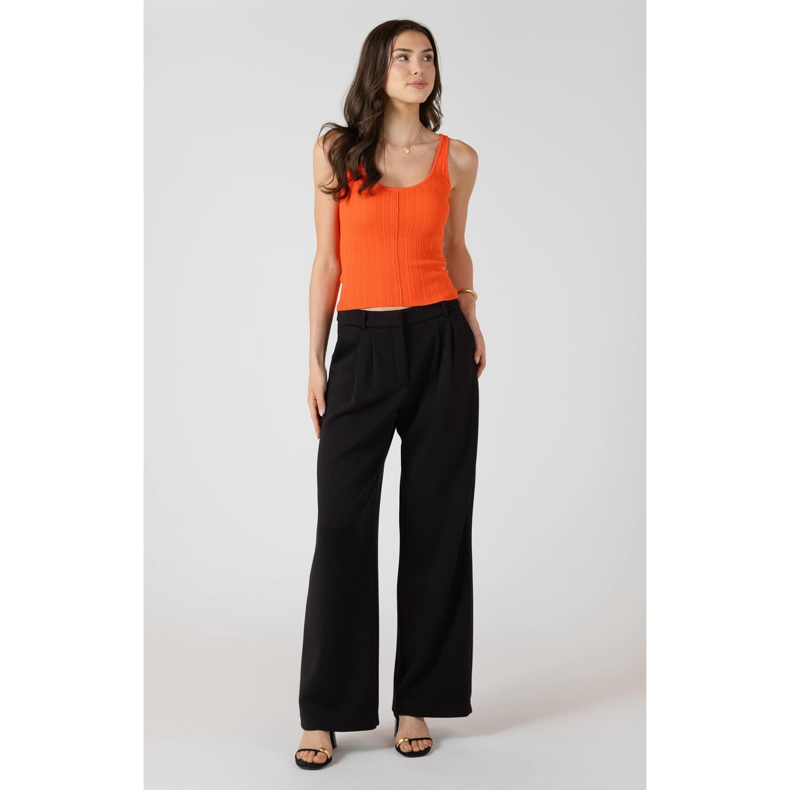 Room 34 Scuba Knit Trouser worn as black wide-leg pants on a model with an orange rib-knit top.