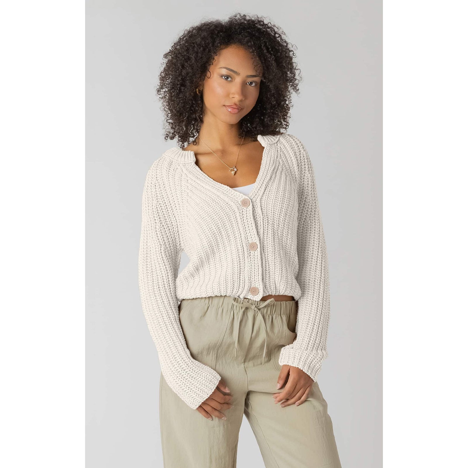Model wearing Room 34 Textured Button Front Cardigan in cream with oversized buttons, cropped knit and long sleeves.