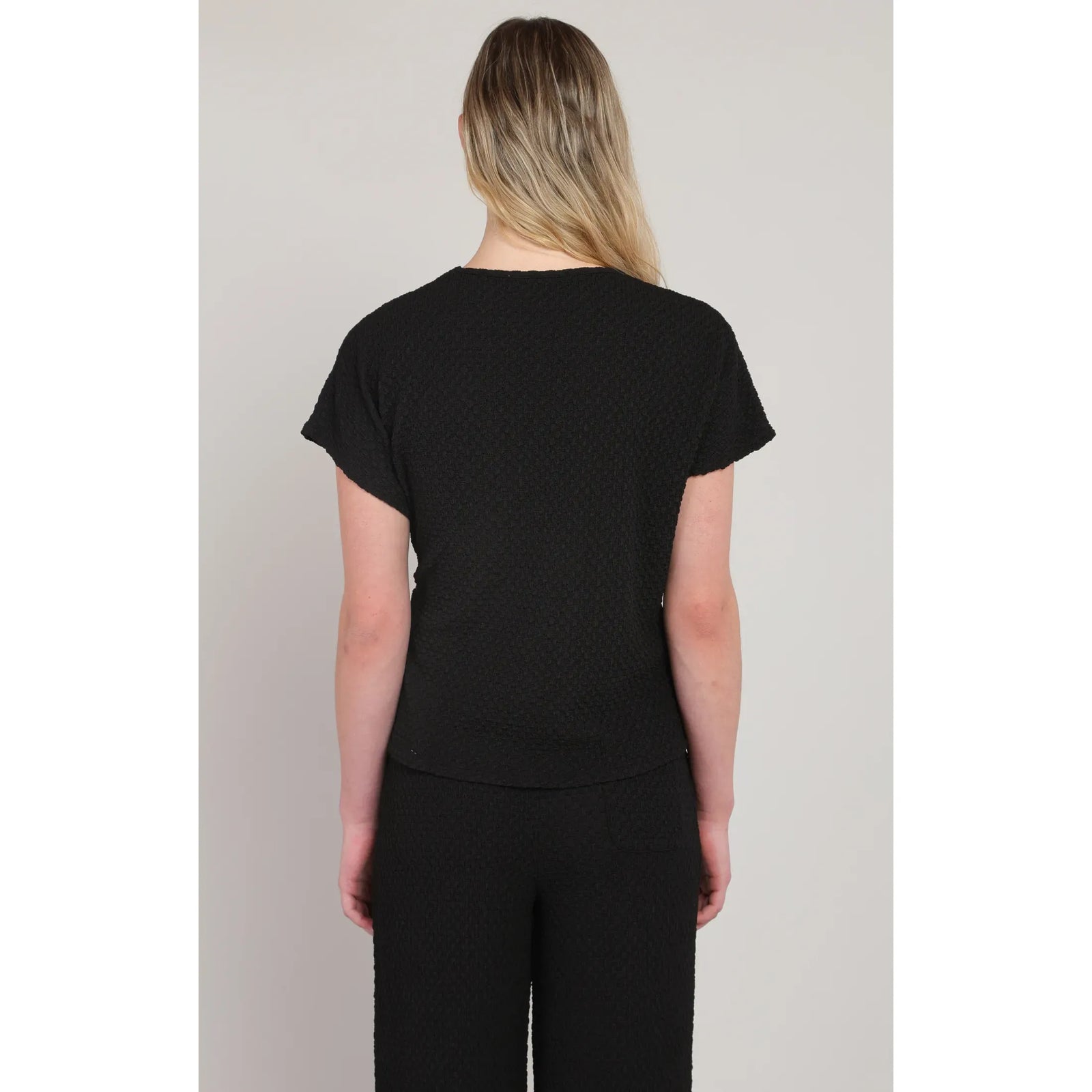 Back view of Room 34 Textured Knot Top in black with a short-sleeve textured knit.