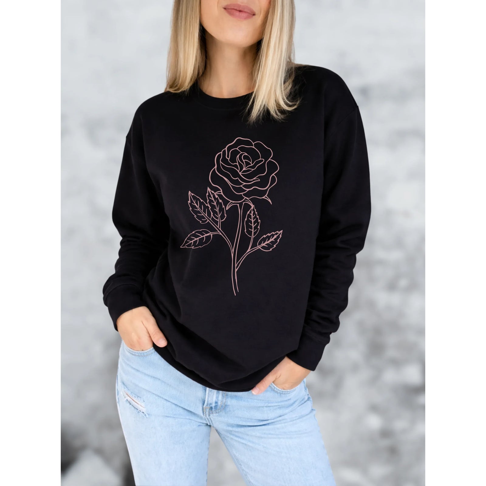 Black crew neck sweater with a pink rose outline on the front, worn by a model.