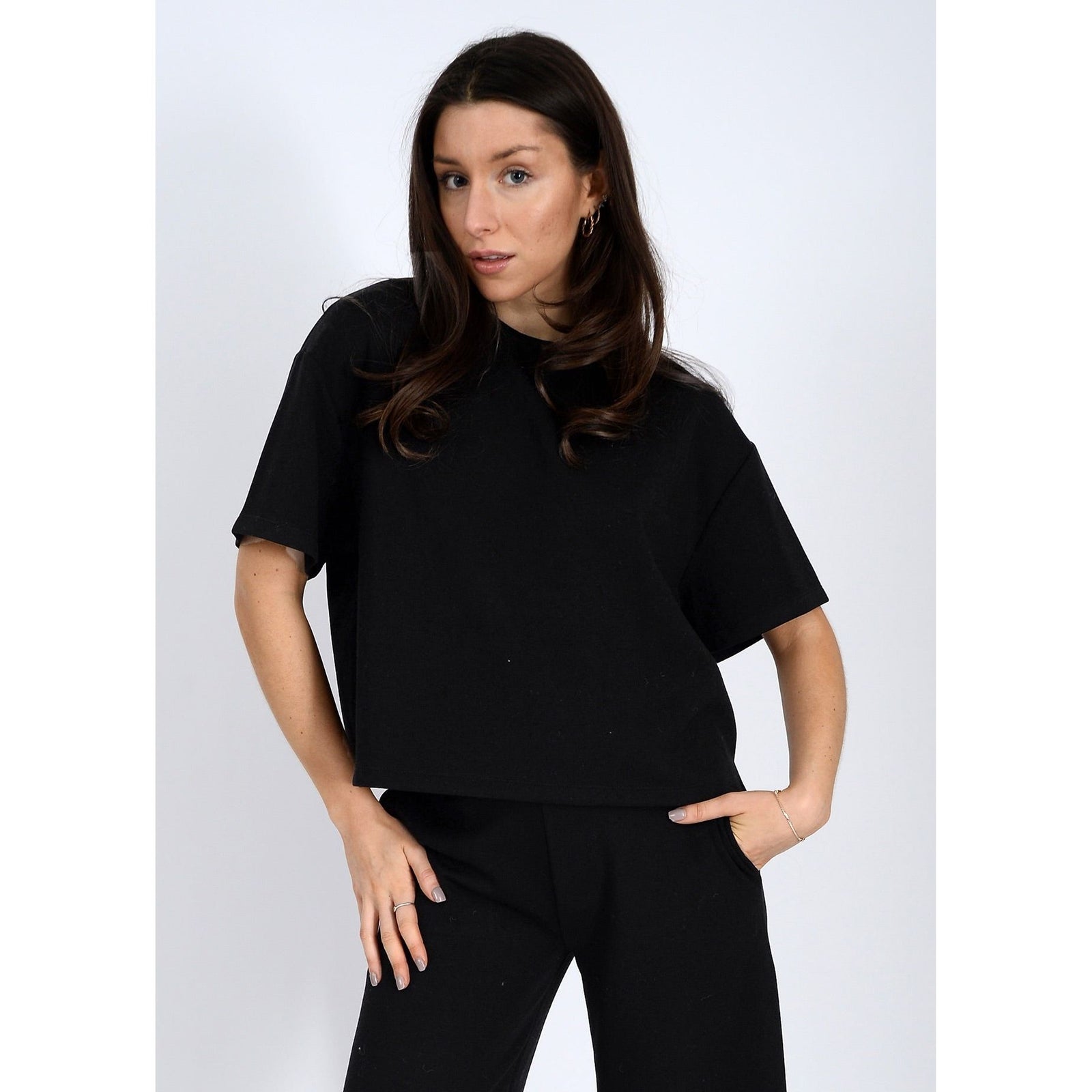 Stylish woman models the Scuba Tess Soft Knit Top in trekking green, ideal for casual outfits or denim pairing.