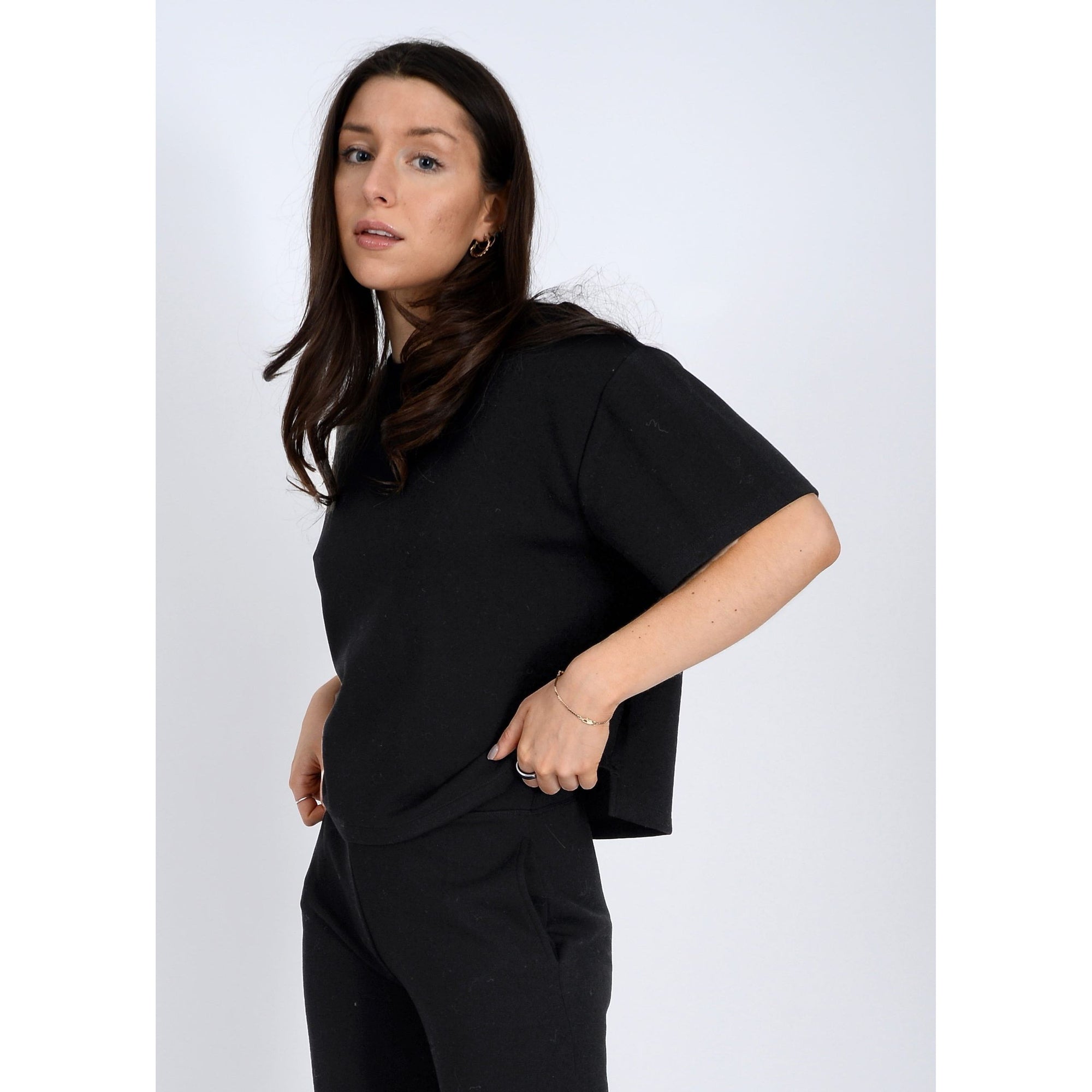 Stylish model wearing the Scuba Tess Soft Knit Top, a cozy black boxy top perfect for any casual outfit.