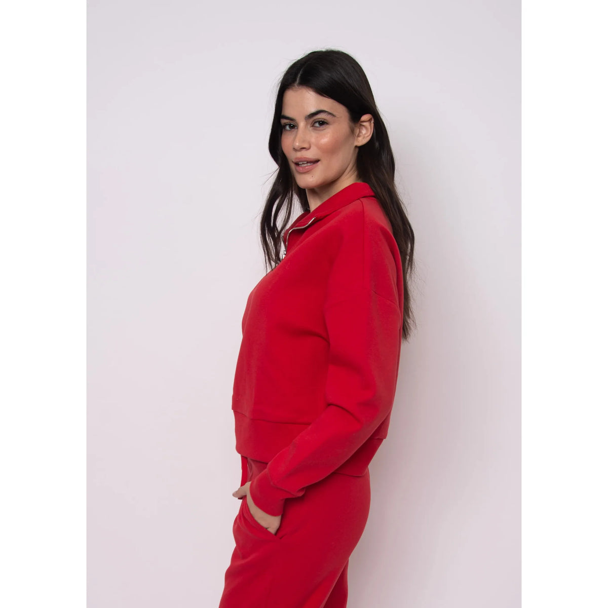 Seanni Soft Knit Half Zip Pullover worn by a woman in a red knit set, side profile.