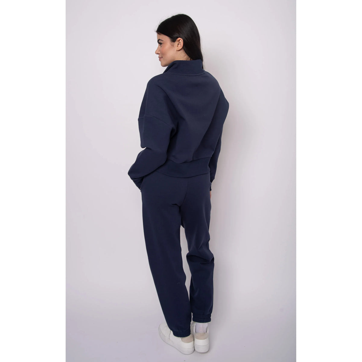 Back view of a model wearing a navy Seanni Soft Knit Half Zip Pullover with matching joggers.