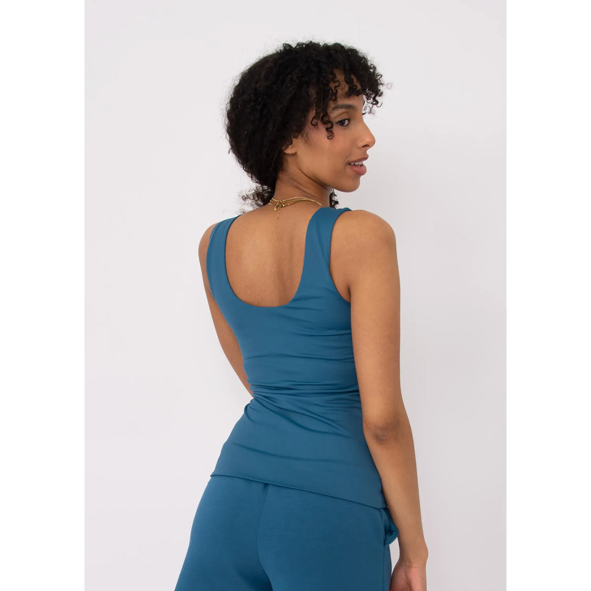 Model wearing teal Second Skin Tanith Double Uneck Tank Top; back view highlights double-uneck neckline.