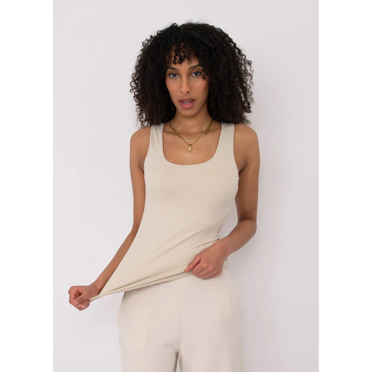 Beige Second Skin Tanith Double Uneck Tank Top worn by model with gold layered necklaces.
