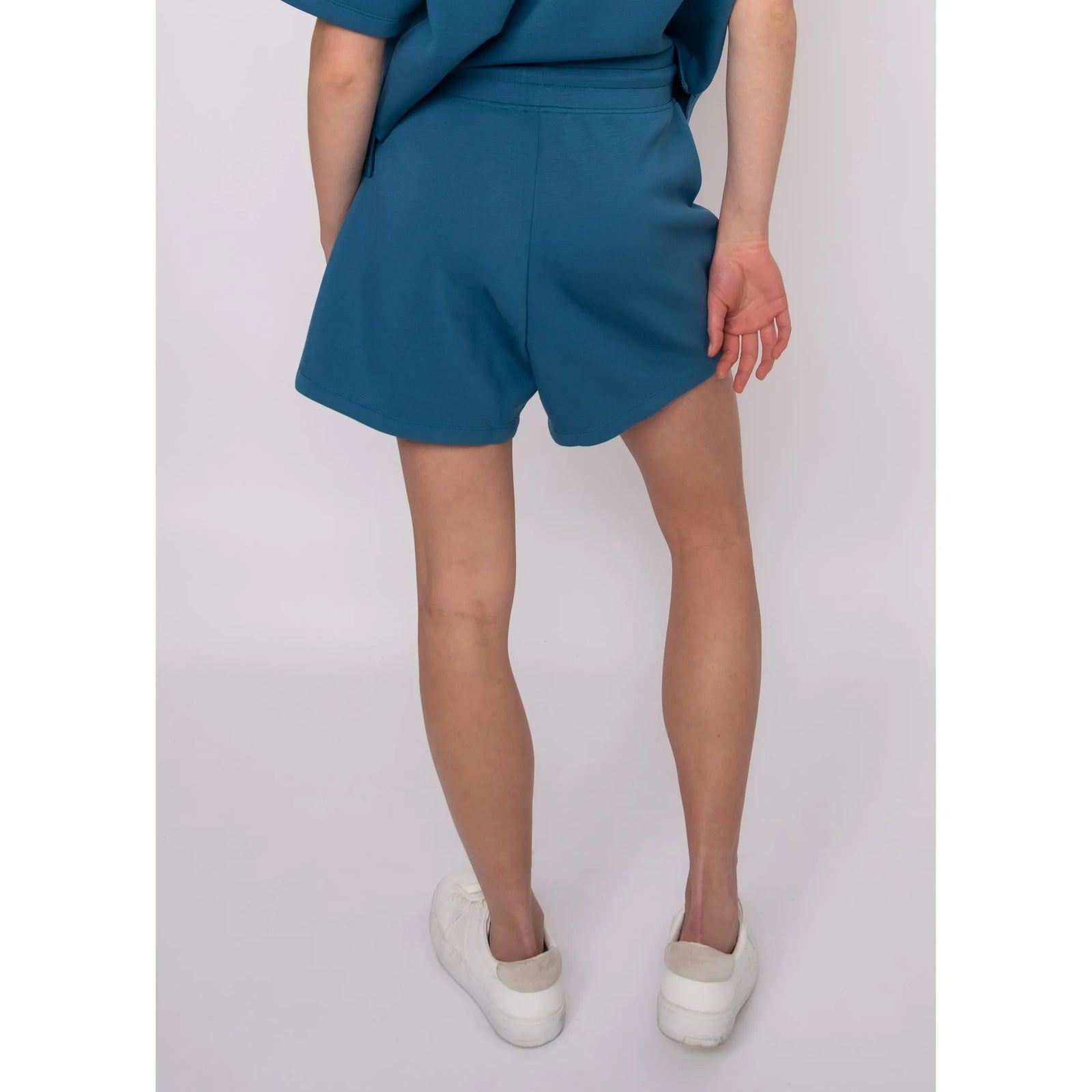 Senza Soft Knit Shorts in teal on model Sharlen, back view with pockets, size S, 5'6"