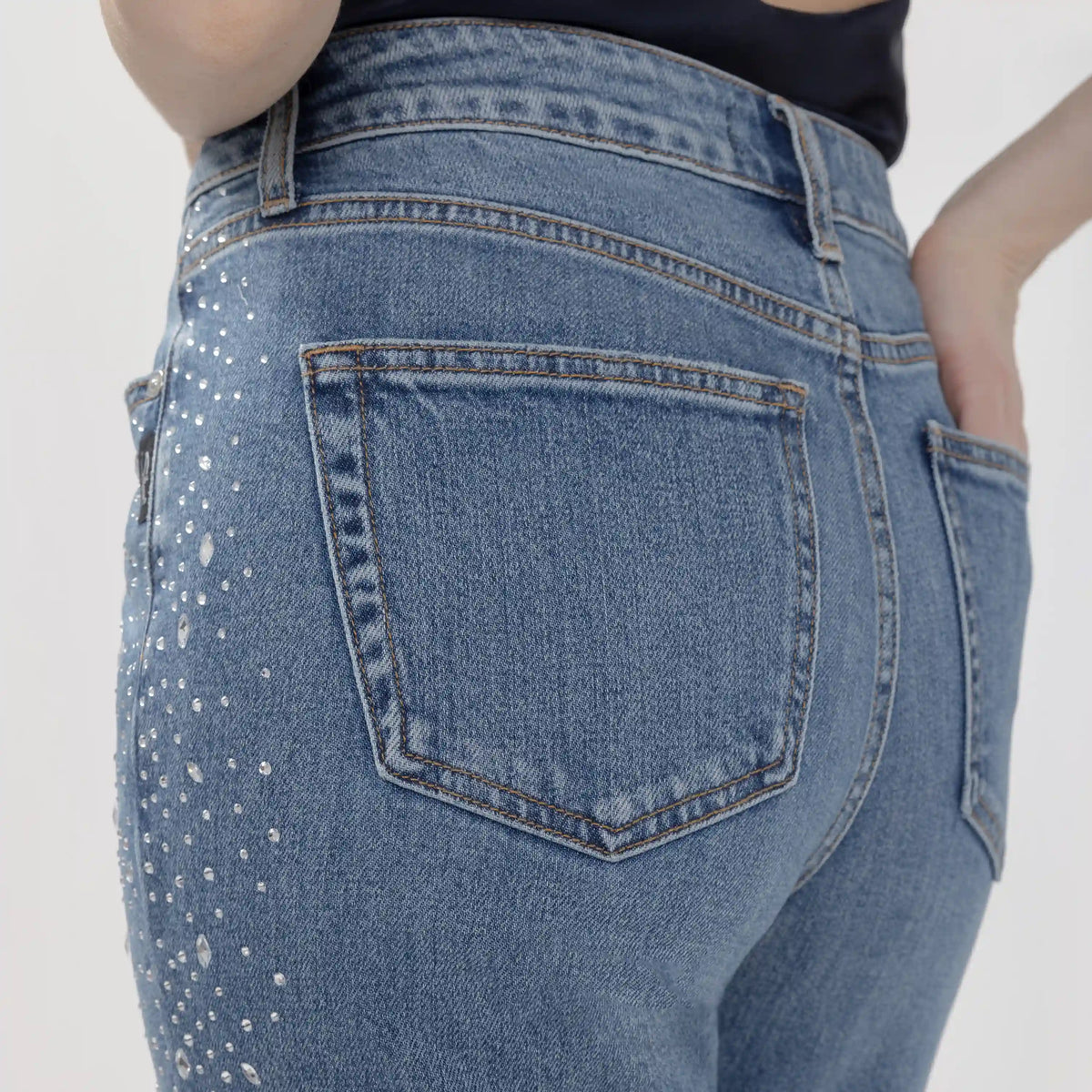 Rear view of silver Avery Wildcard jeans featuring crystal embellishments on the thigh and a contoured back pocket.