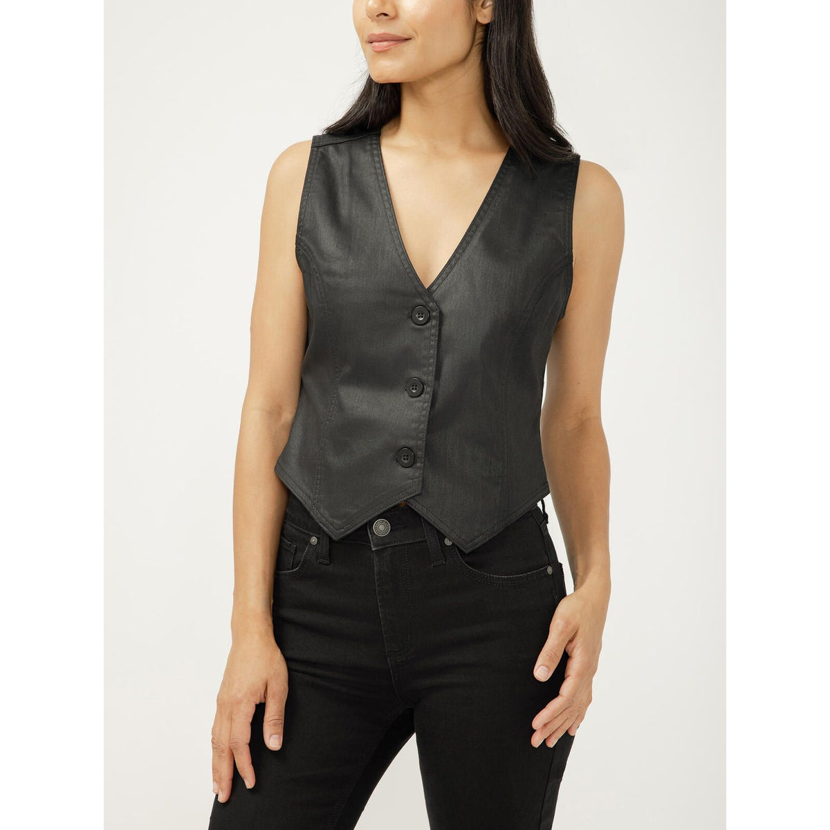 Model wearing a silver-black coated denim vest with a V-neck, sleeveless, button-front and a pointed hem.