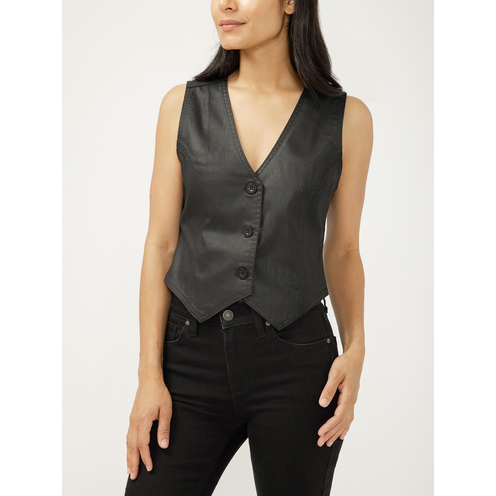 Model wearing a silver-black coated denim vest with a V-neck, sleeveless, button-front and a pointed hem.