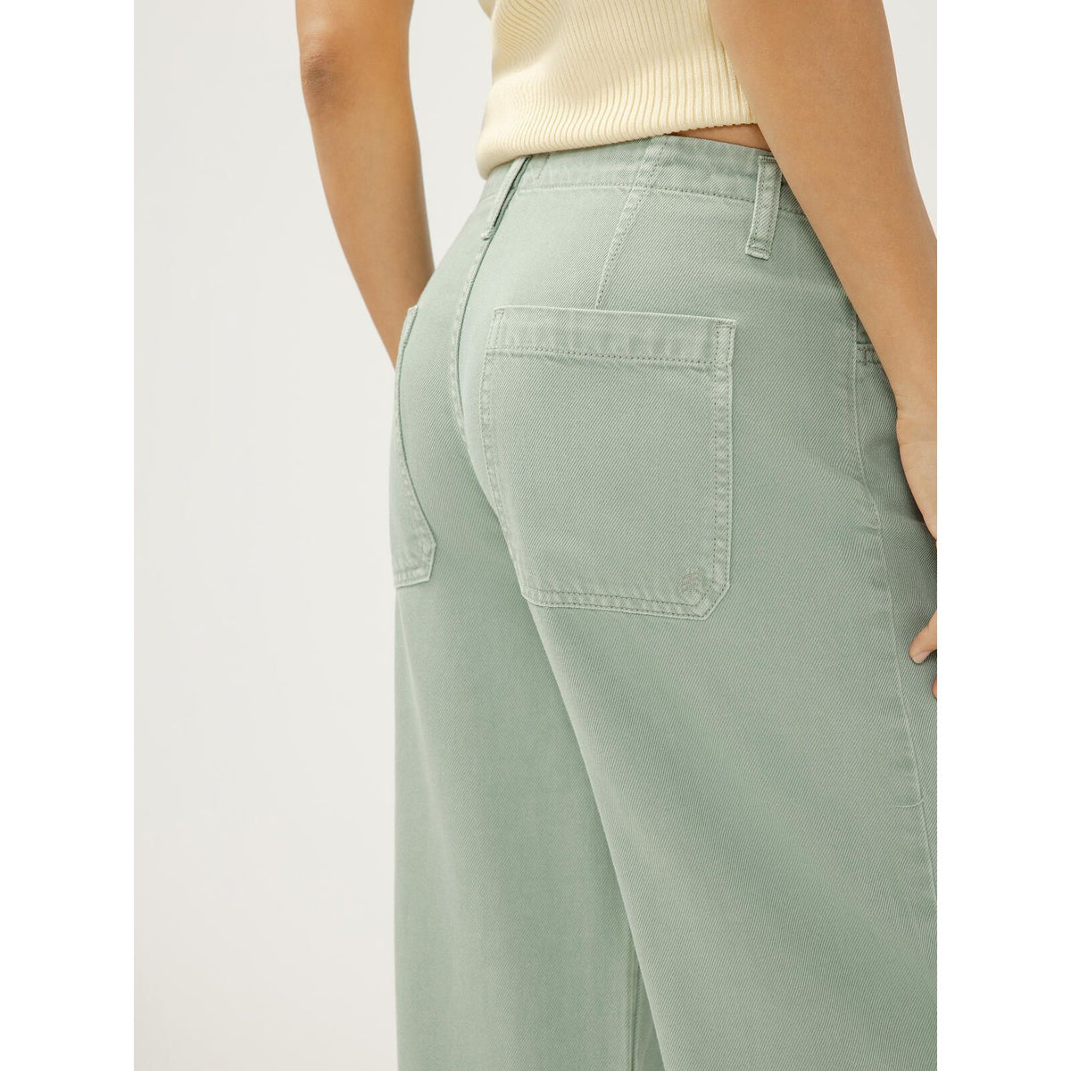 Light sage-green wide-leg denim pants with back pockets and relaxed fit.