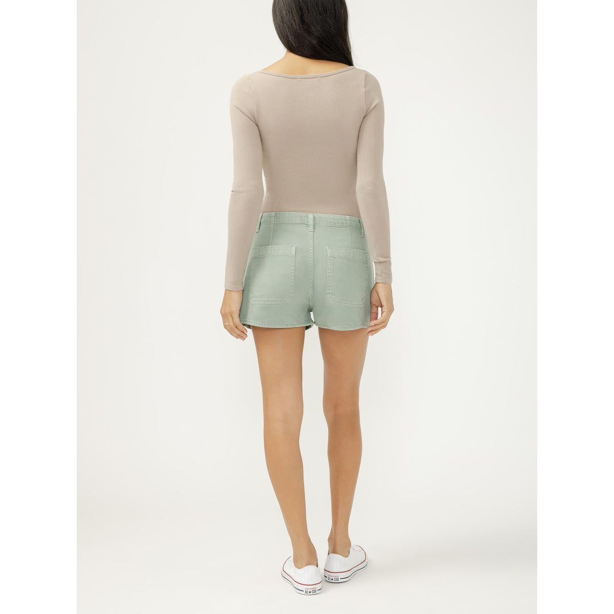 Back view of a model in beige ribbed top wearing pastel green drawstring beach shorts with rear pockets