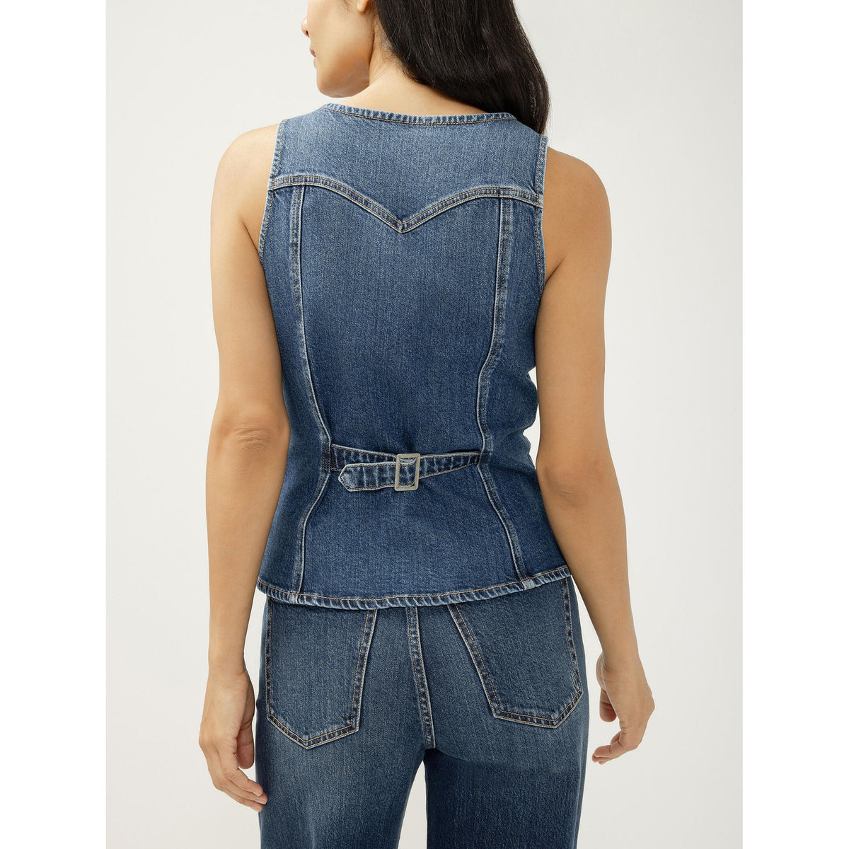 Back view of a sleeveless blue denim vest with a waist belt and V-shaped yoke.