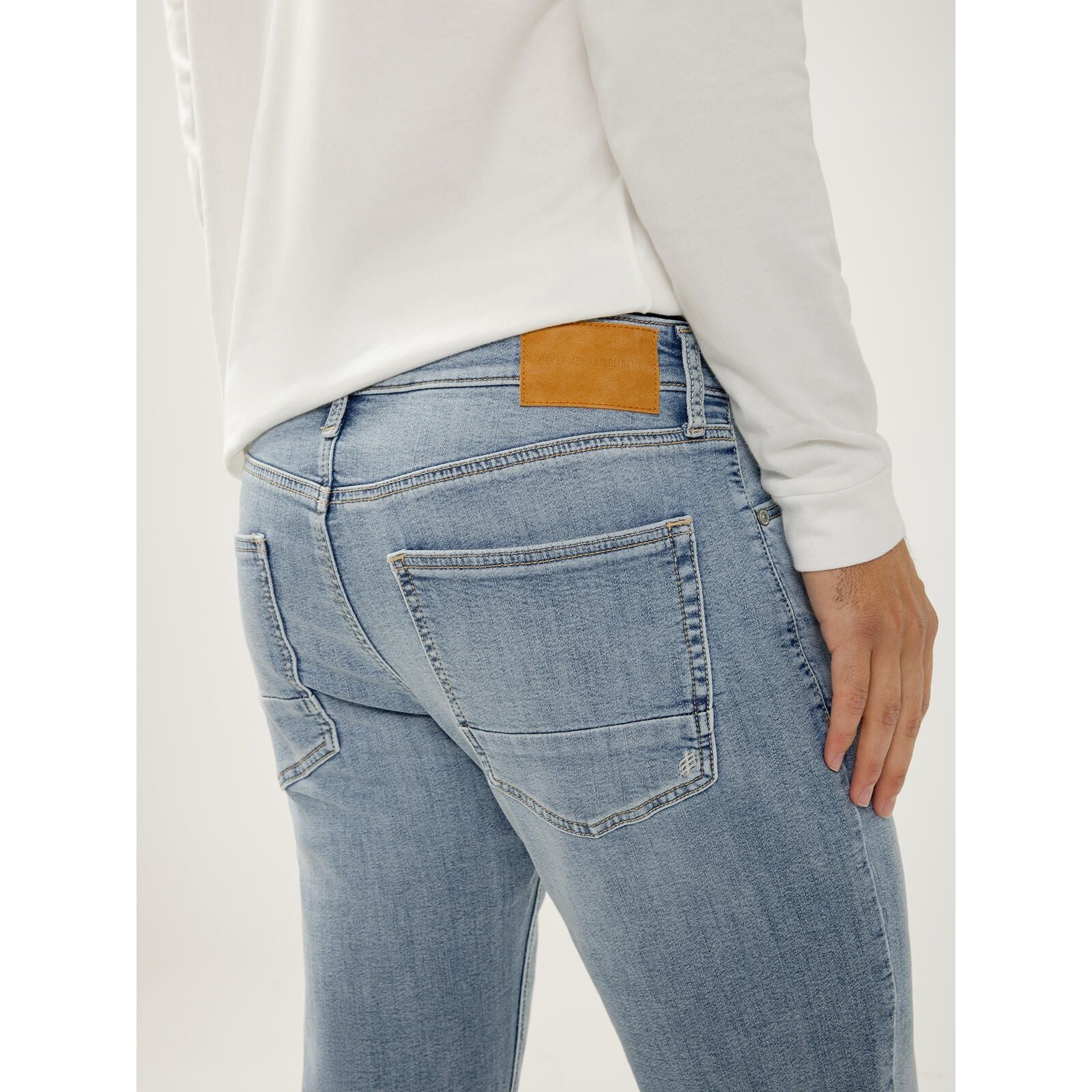 Silver Machray Slim Straight Leg jeans in Wild, back view with tan leather patch and white shirt.
