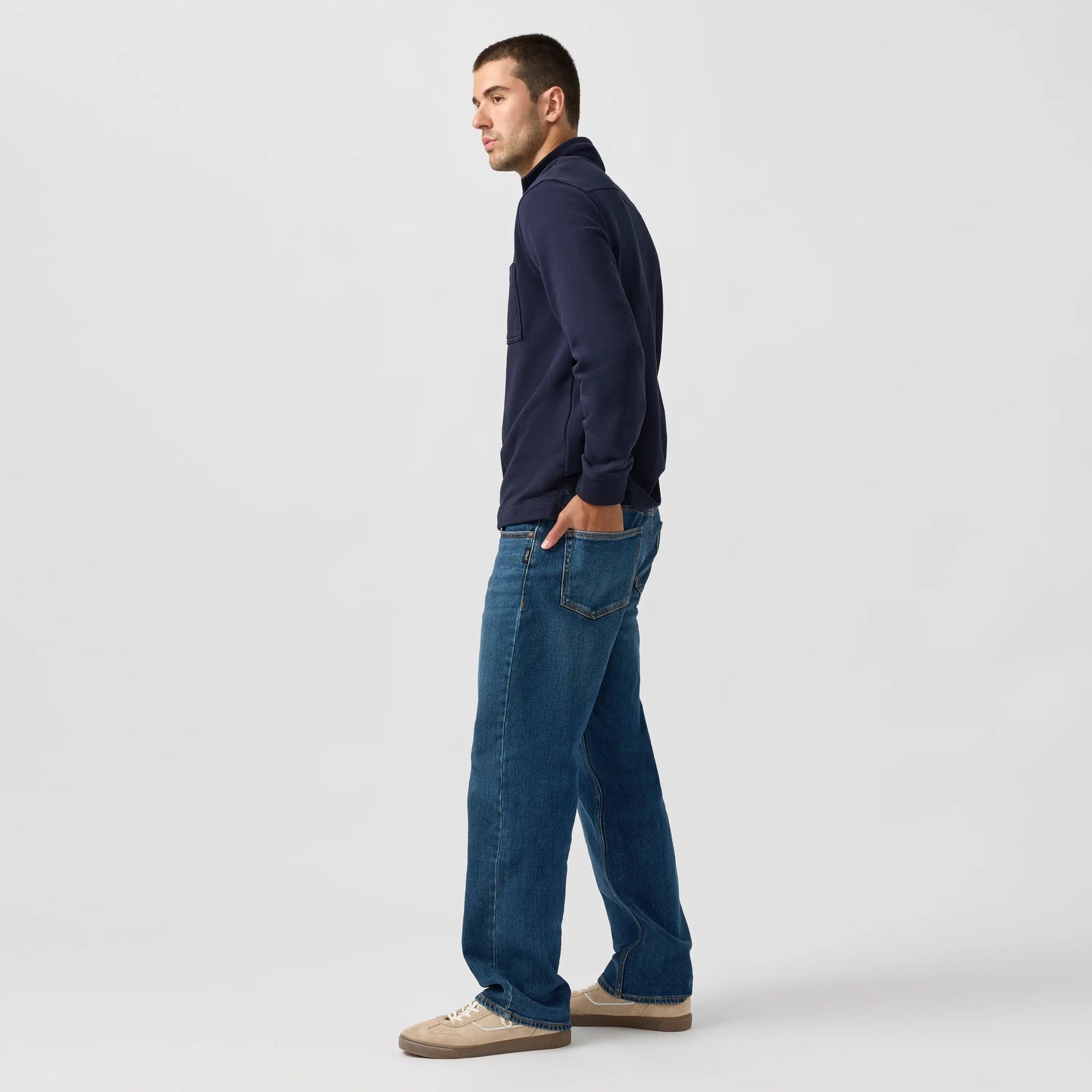 Man modeling silver relaxed straight leg jeans in a deep Y2K-inspired rocky indigo wash with soft stretch denim.