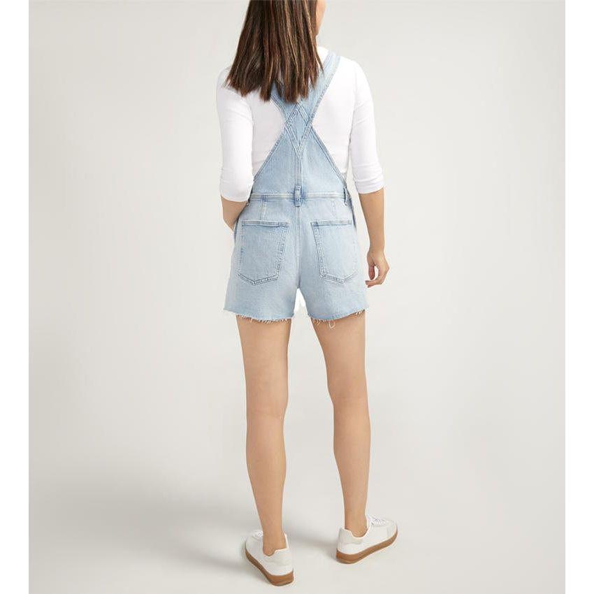 Stylish Silver Shortalls Indigo featuring light distressing, adjustable straps, and a trendy open back for spring vibes.