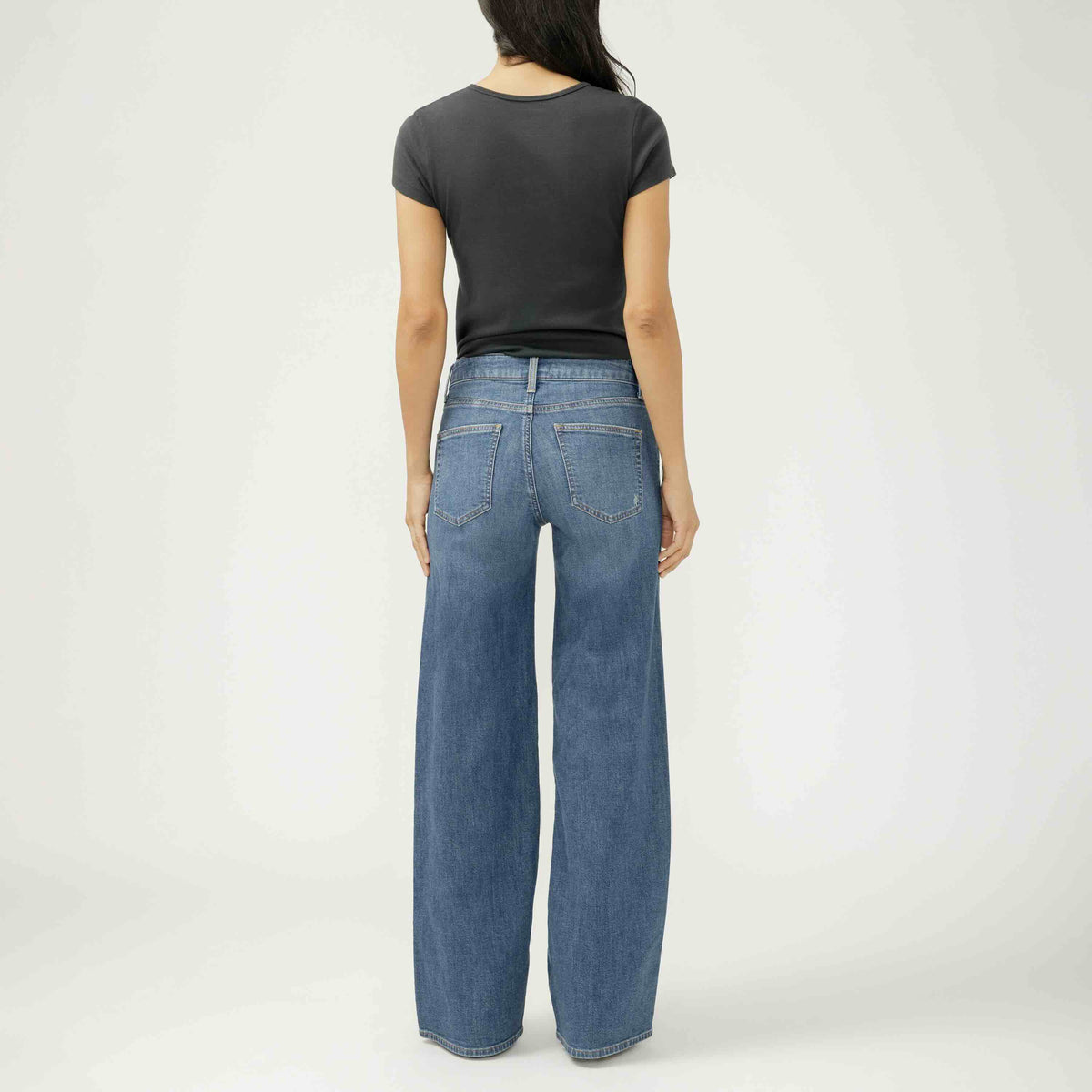 Back view of a model wearing Silver Suki Wide Leg in Broydon, dark indigo wide-leg jeans.
