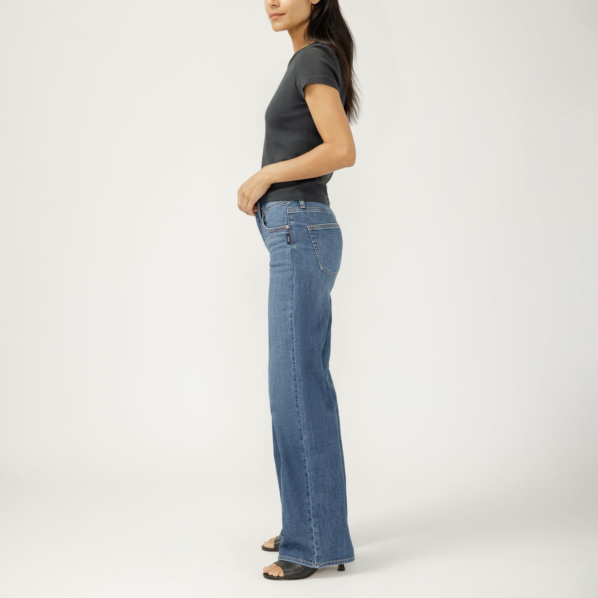 Side view of a model wearing Silver Suki Wide Leg in Broydon jeans with a contoured waistband in dark indigo.