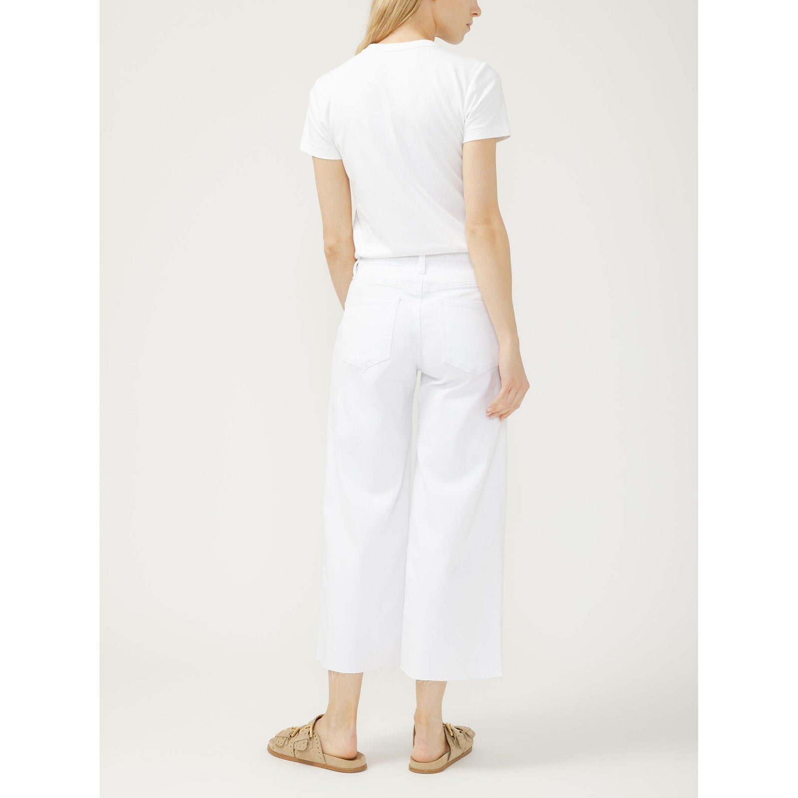 Silver Suki wide-leg cropped jeans in white on a model with a white tee and tan sandals.